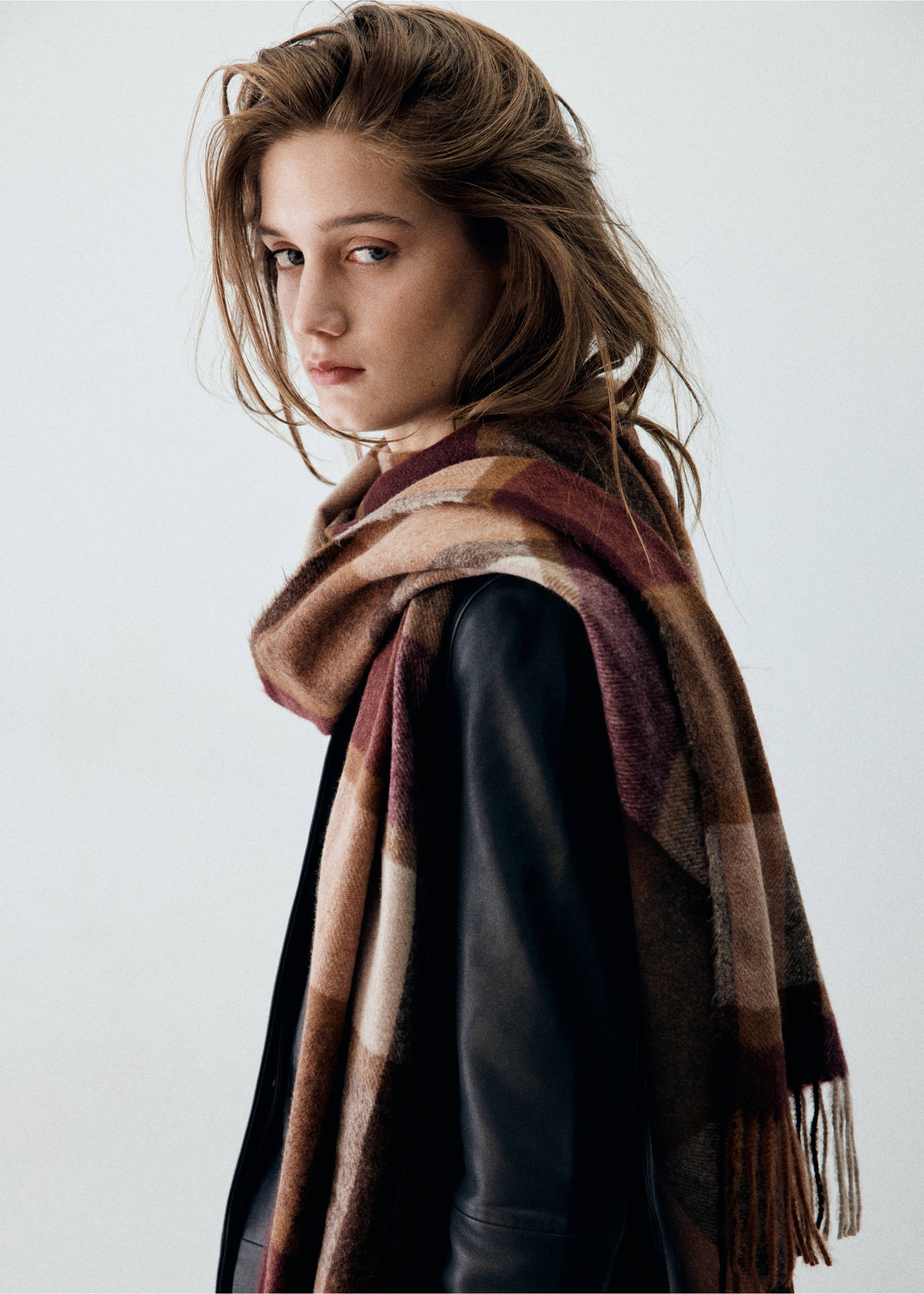 Burgundy and brown plaid scarf with fringe, worn over a dark jacket., Burgundy. Ref: 37035979-00.