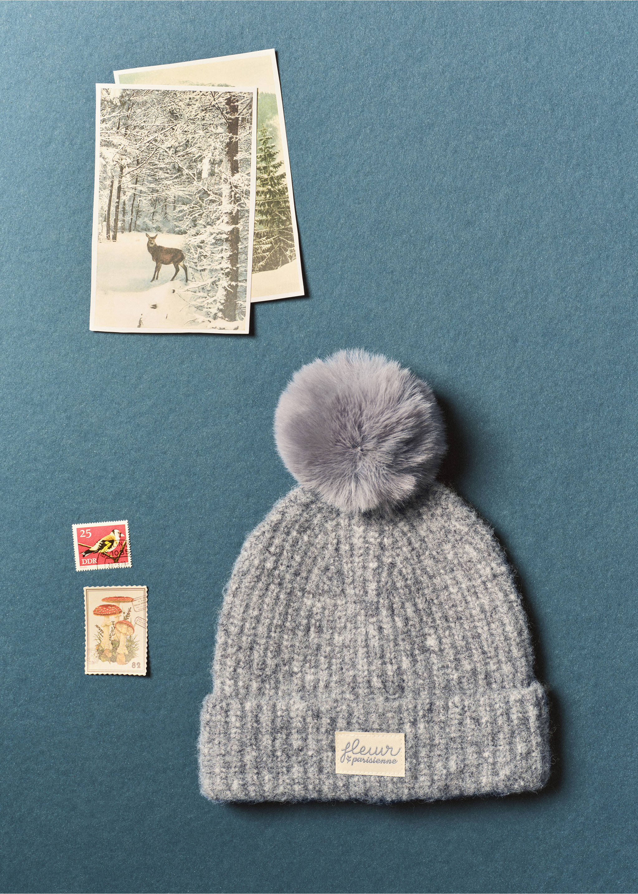 Grey speckled knit beanie with a turn-up cuff, cream brand patch, and a grey faux-fur pompom., Grey. Ref: 37035994-00.