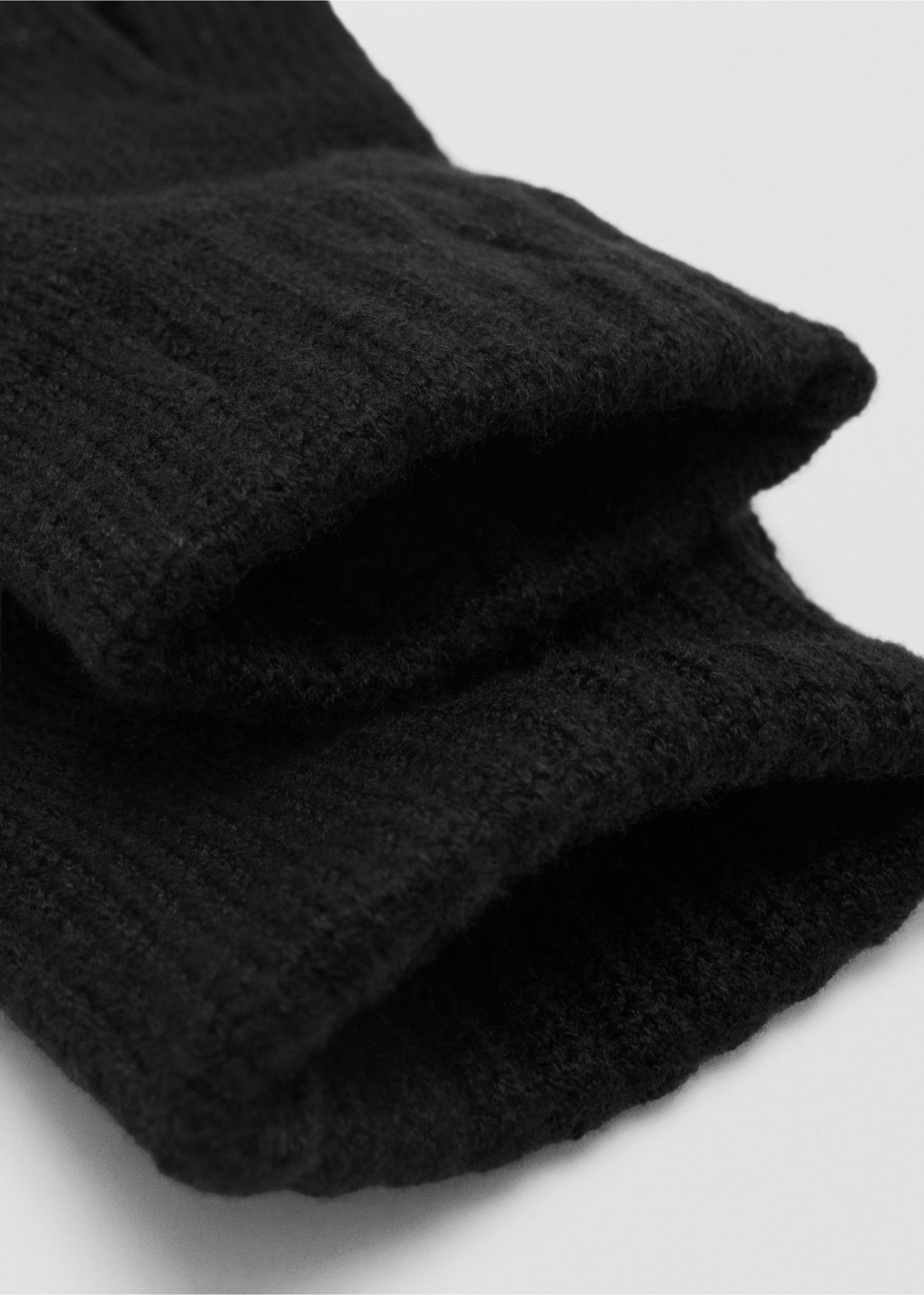 Close-up of black knitted gloves showing ribbed cuffs., Black. Ref: 37035999-00.