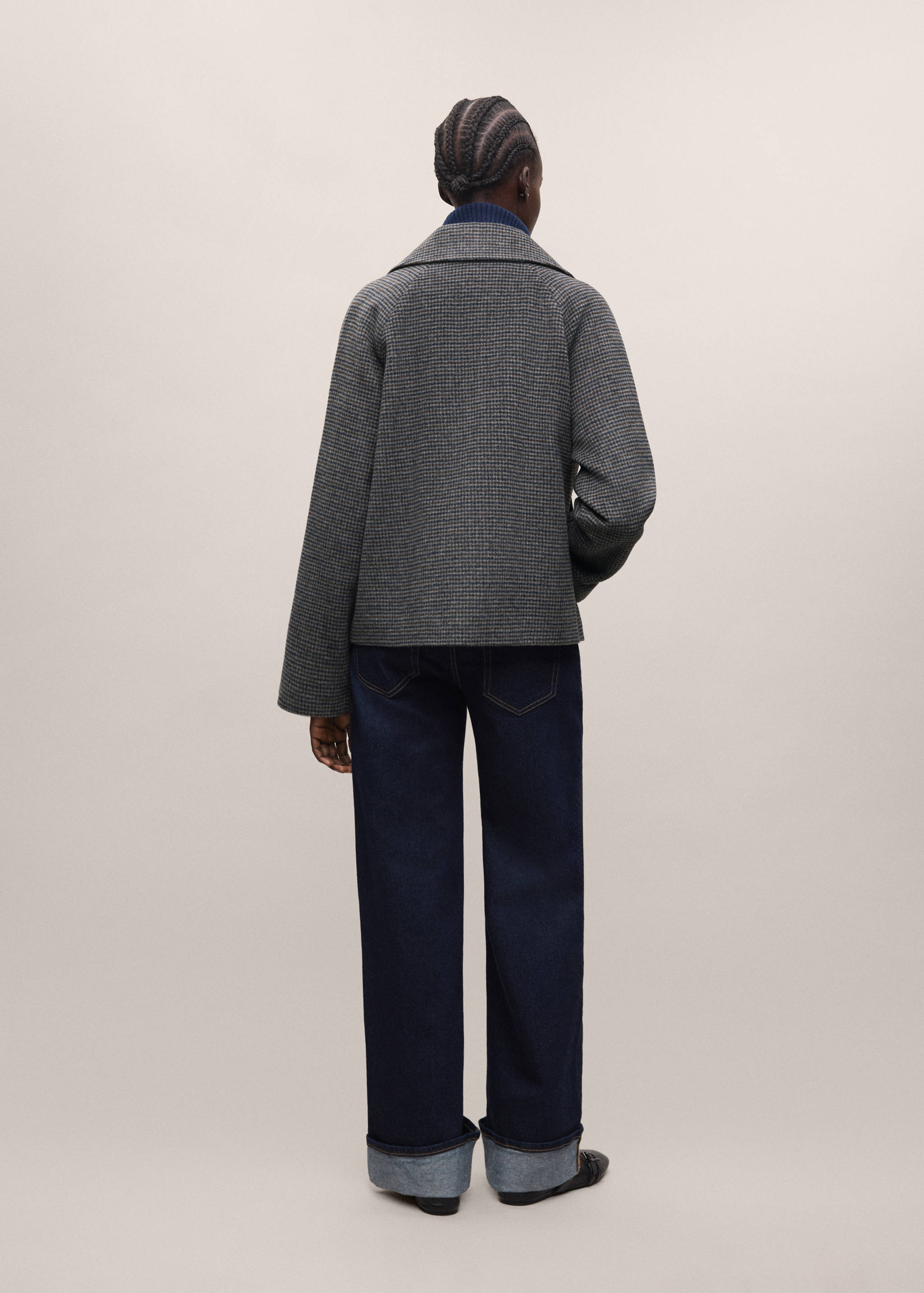 Back view of a grey houndstooth coat with wide collar and piping.