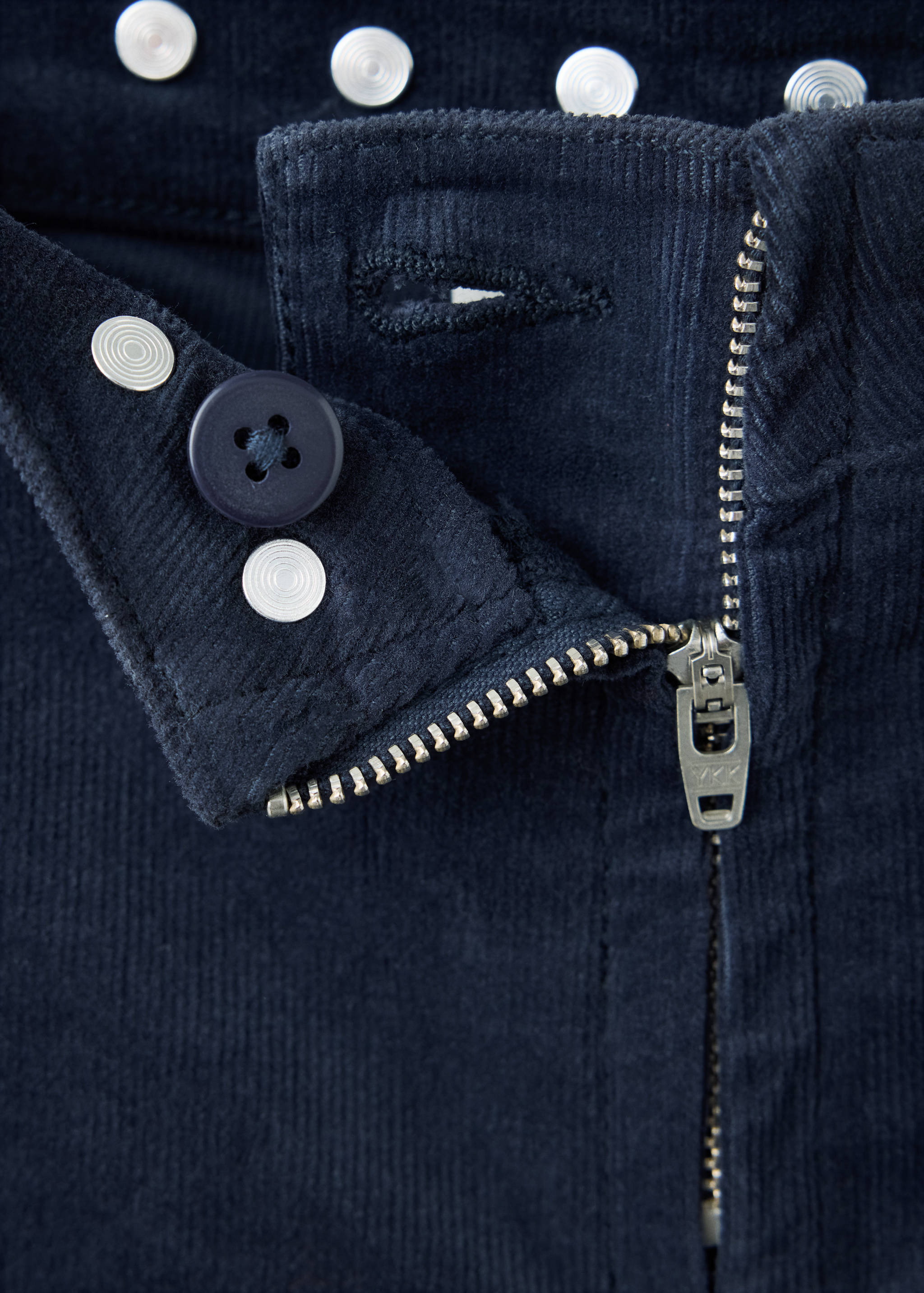 Navy blue corduroy trousers fly and waistband detail.