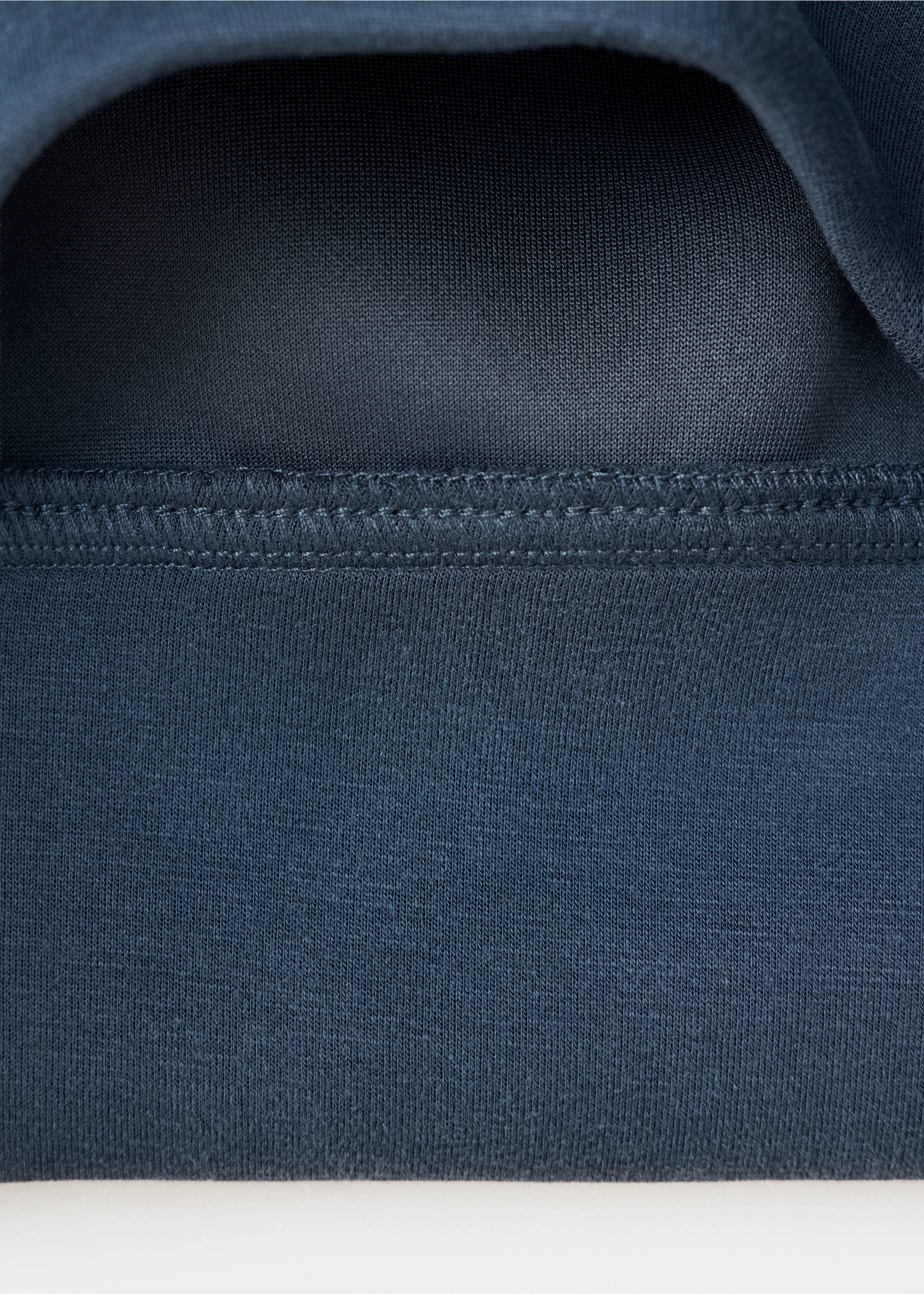 Close-up of the dark blue fabric texture and stitched hem of a sweatshirt., Navy. Ref: 37036747-00.