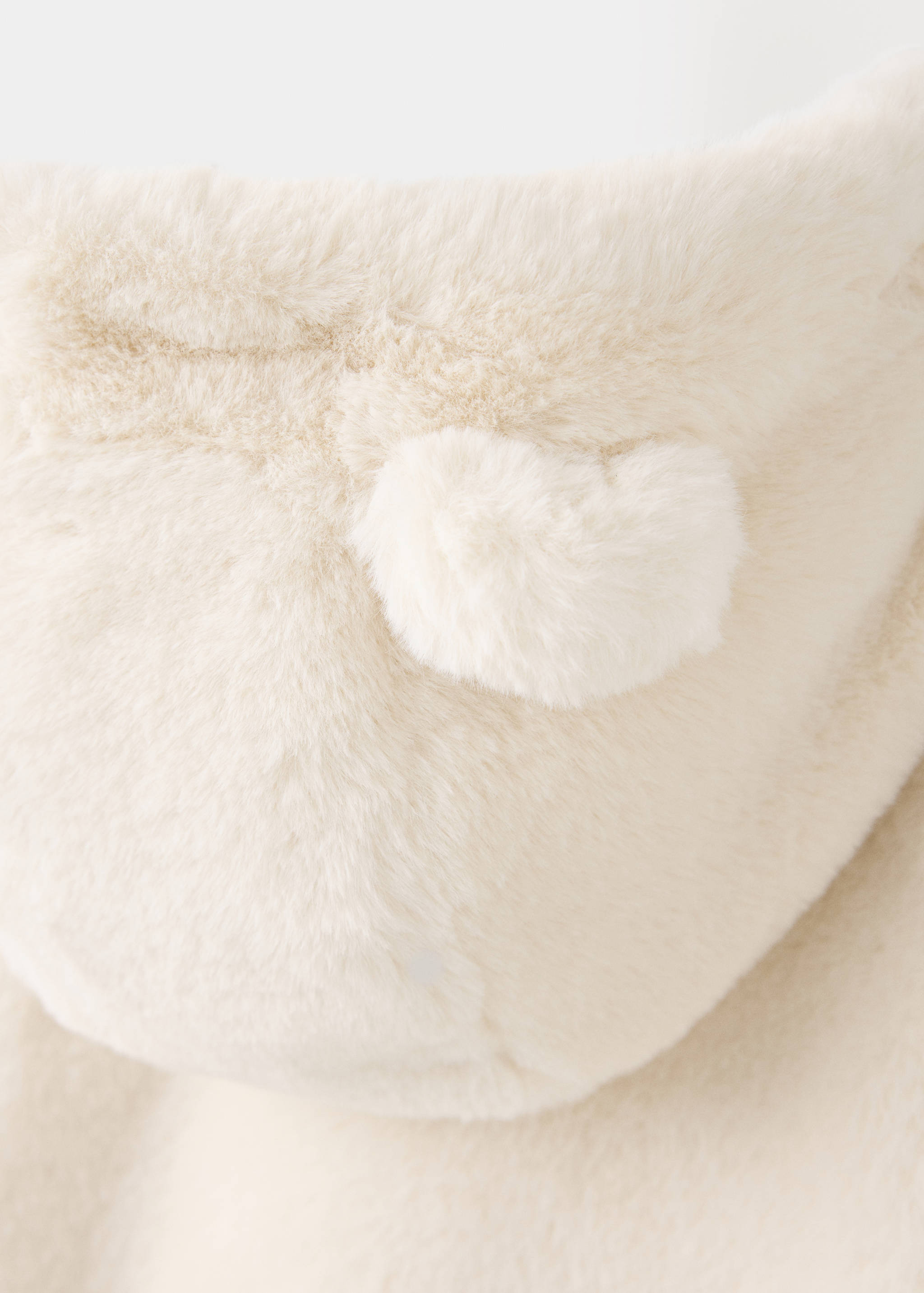 Close-up of white faux-fur coat hood with a small ear detail.