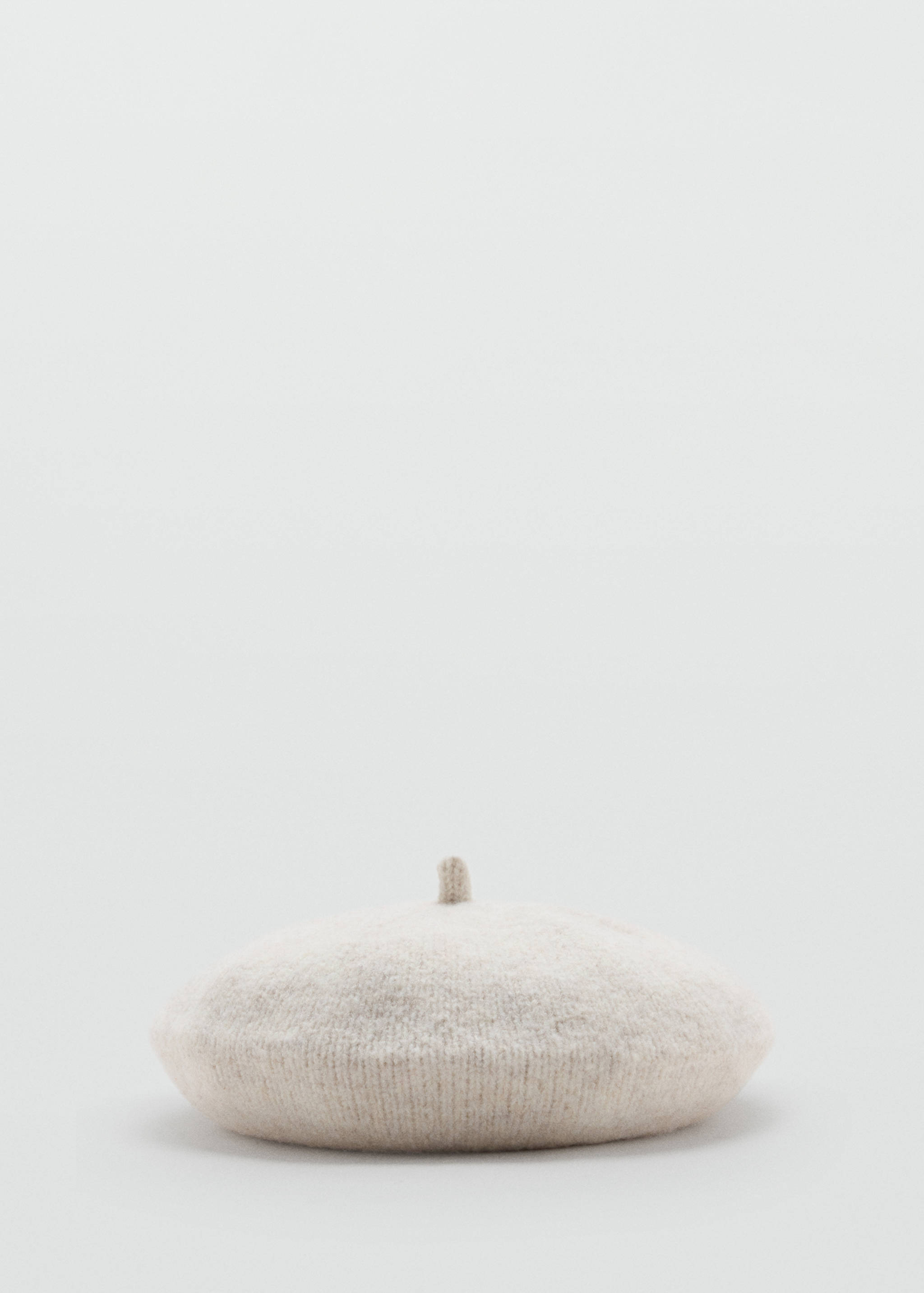 Beige knit beret with a textured finish and small top stem.