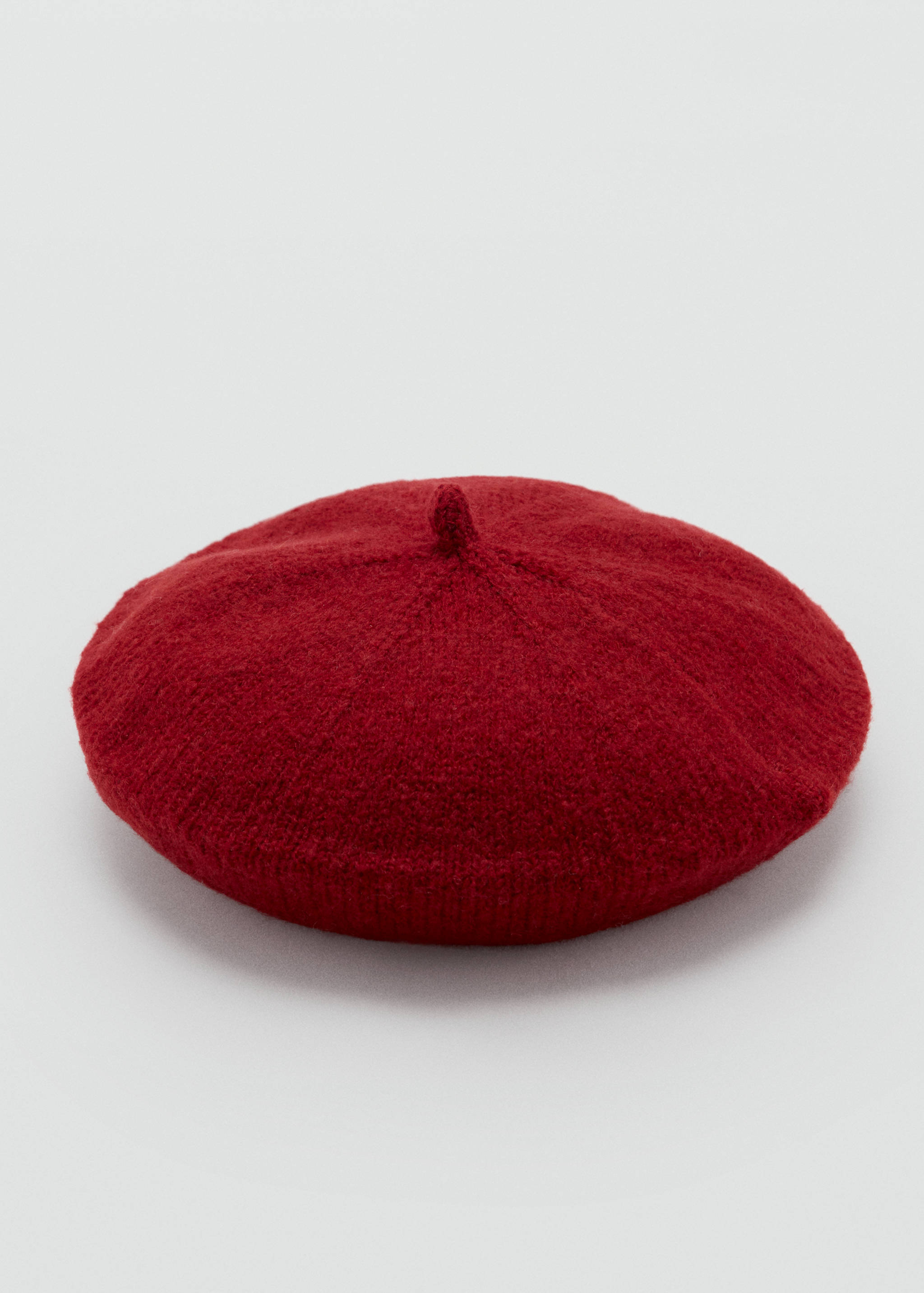 Red knitted beret with a textured finish and a small top knot.