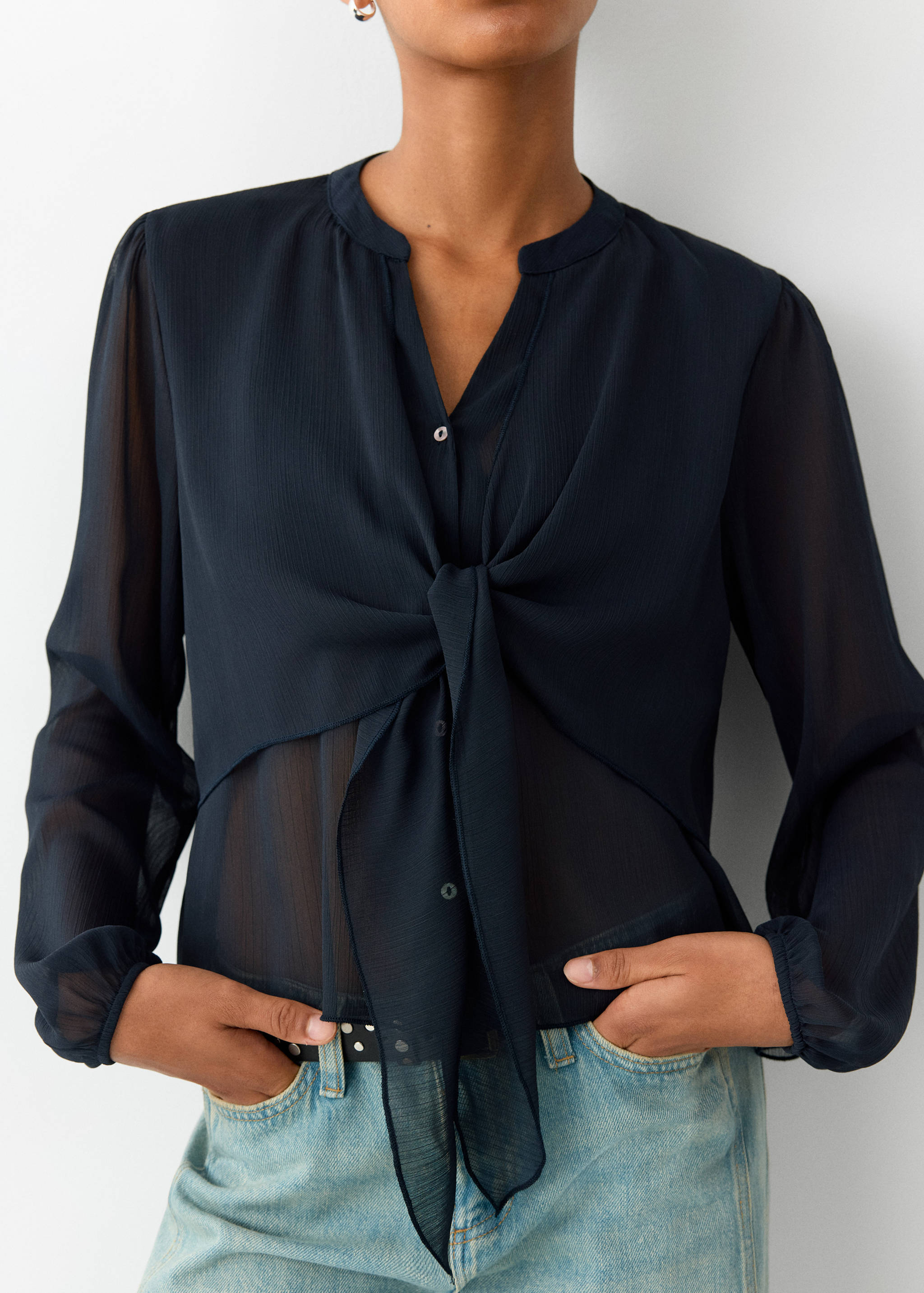 Dark navy blue sheer long-sleeve blouse with a front knot and band collar.