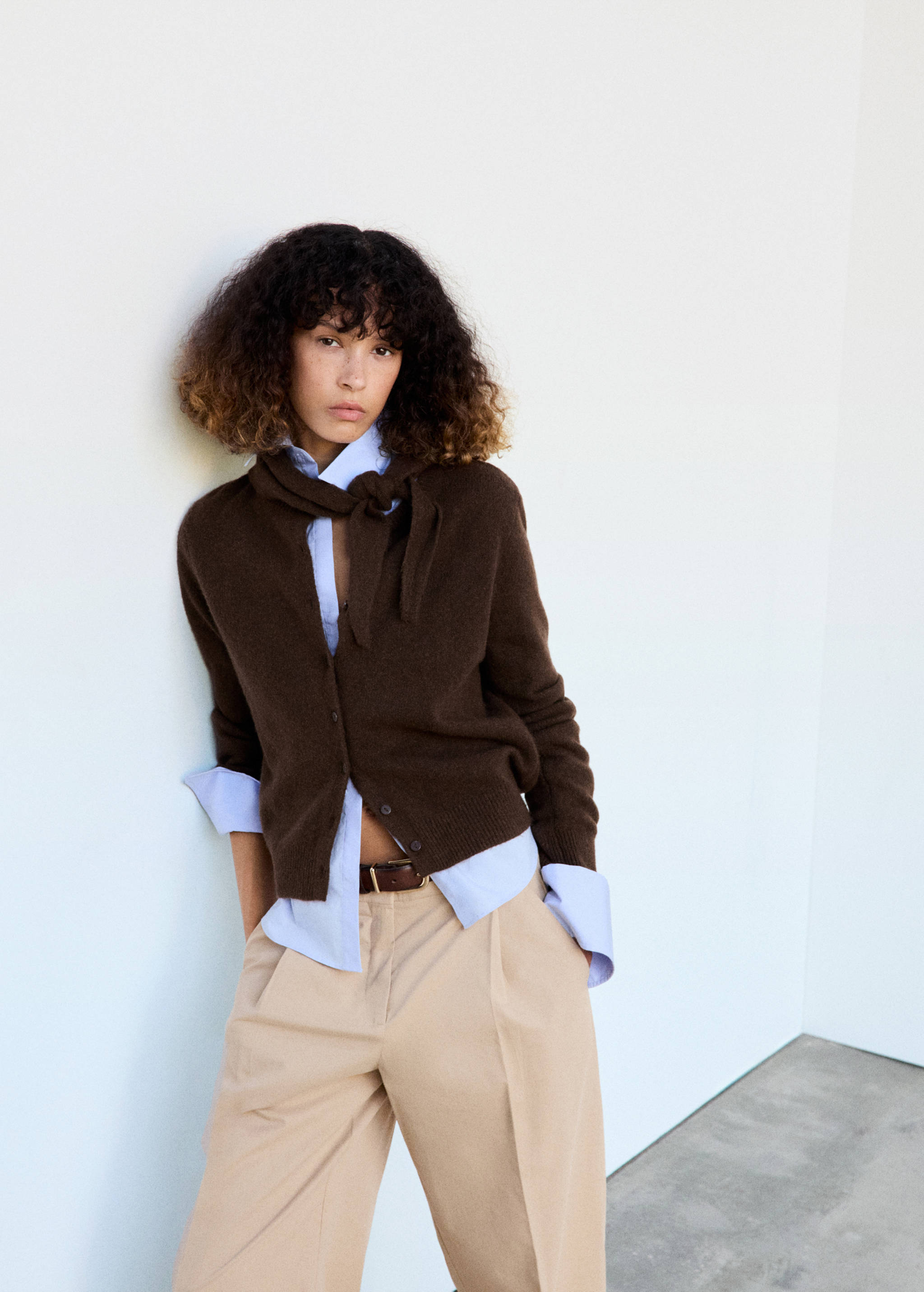 Dark brown button-up knit cardigan with a matching neck scarf, layered over a light blue shirt.