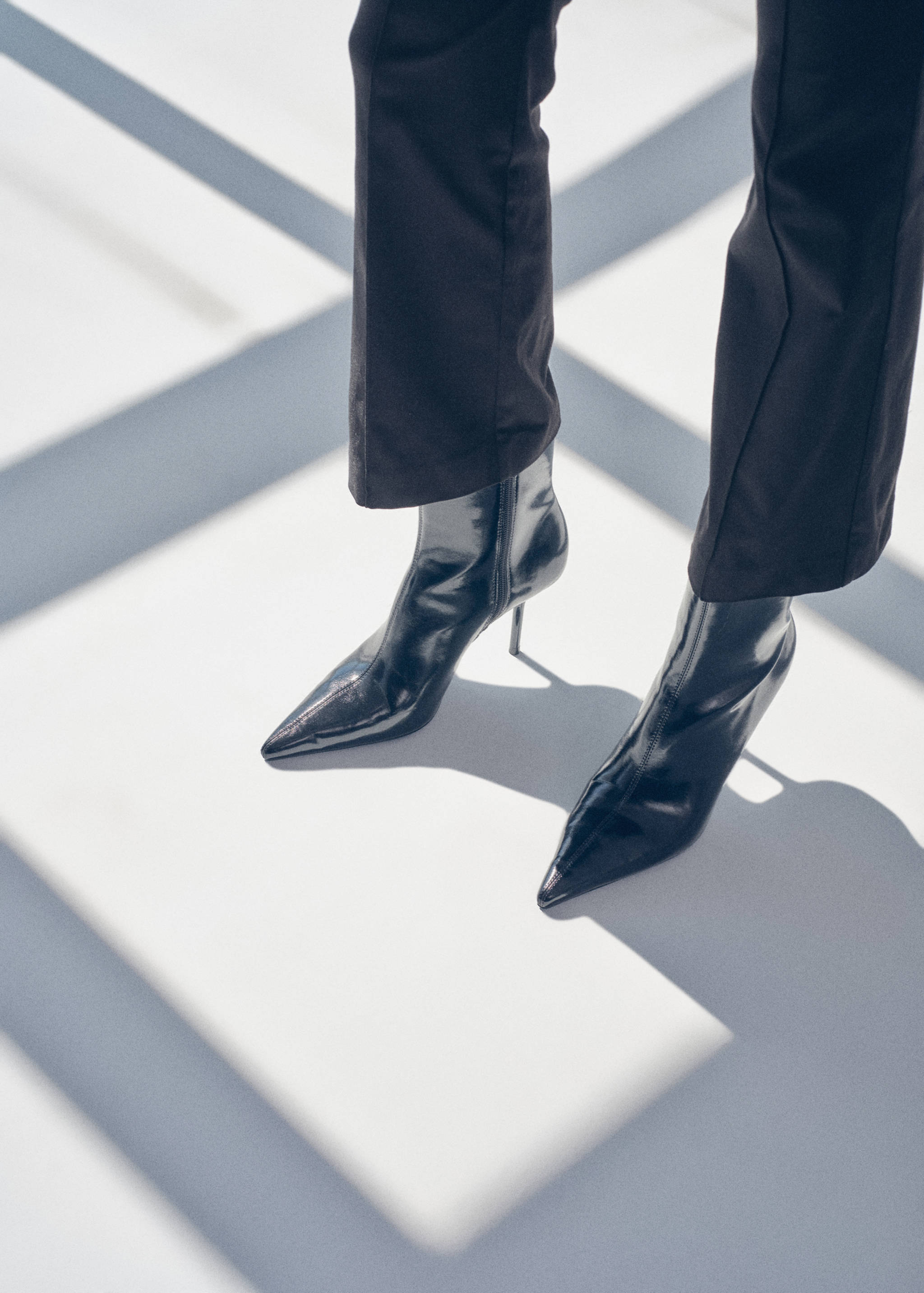 Black patent ankle boots with pointed toes and stiletto heels.