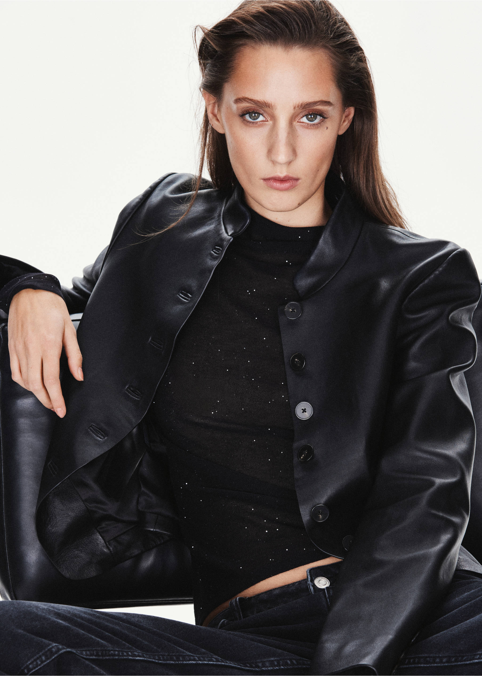 Black sparkling top with a stand-up collar, worn under a black faux-leather jacket., Black. Ref: 37037781-00.