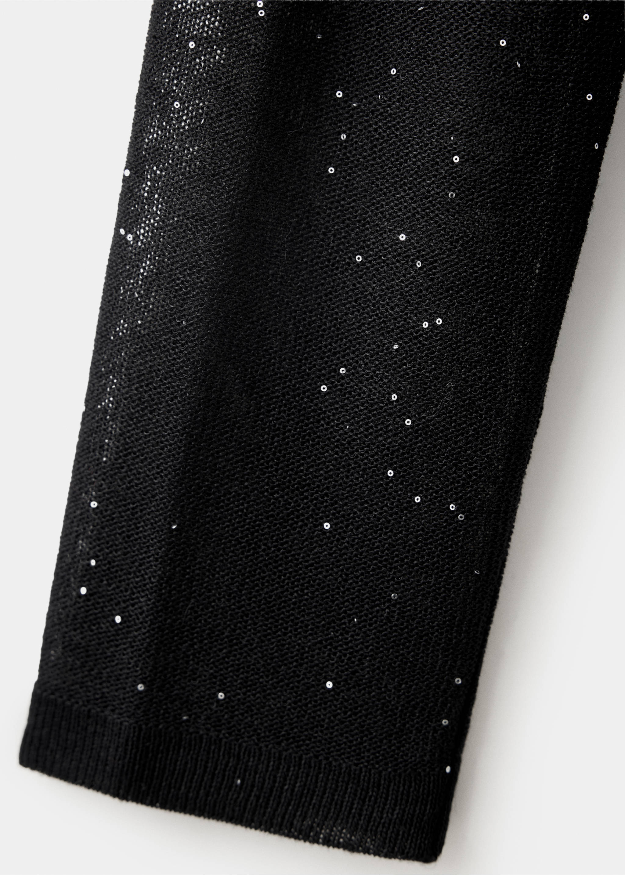 Close-up of a black semi-sheer knit top with scattered silver sequins., Black. Ref: 37037781-00.