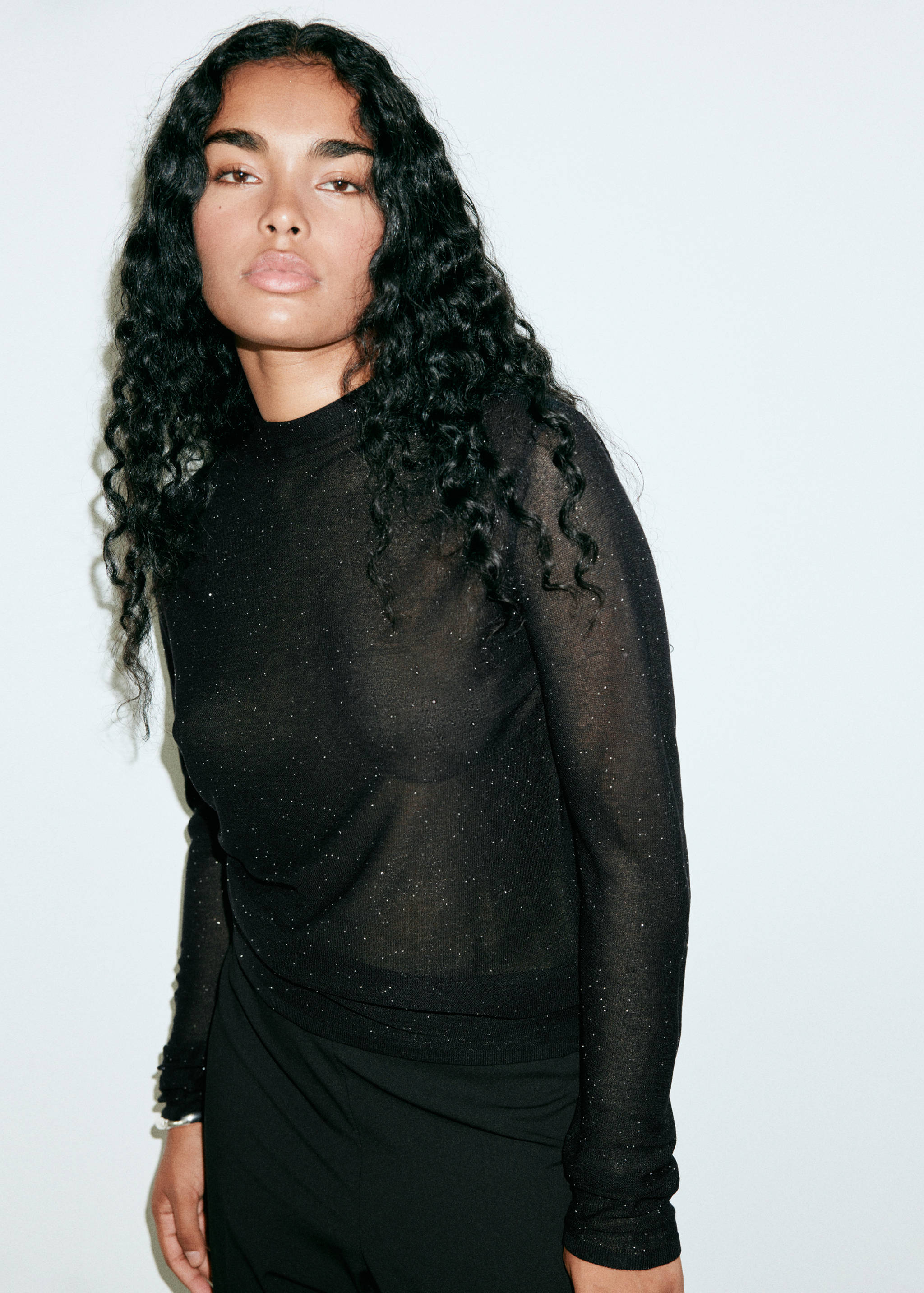 Black sheer glitter top with a high neckline and long sleeves.