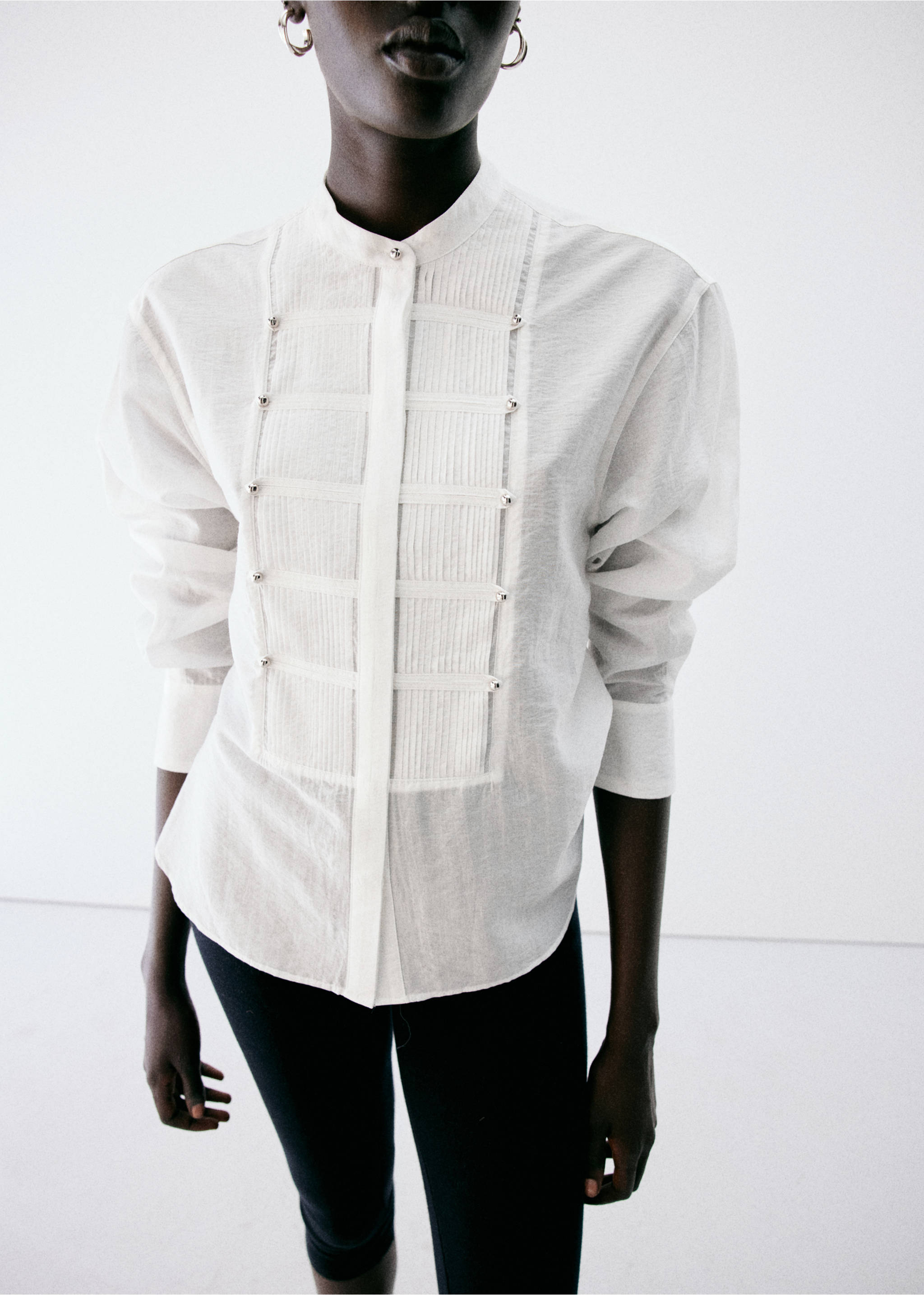 White long-sleeve blouse with a pleated bib and metallic button details., White. Ref: 37037783-00.