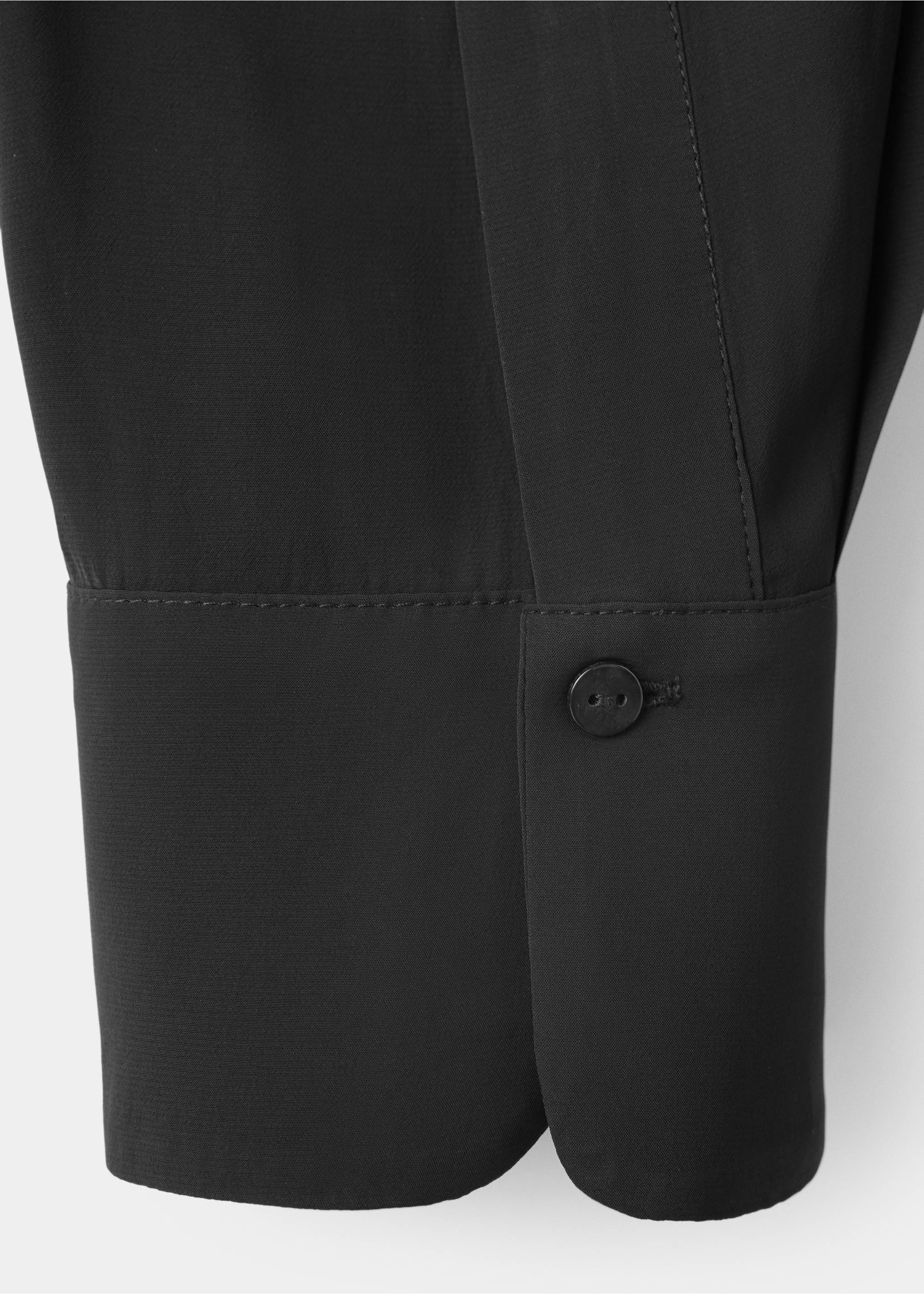 Close-up of a black blouse cuff with a single button., Black. Ref: 37037784-00.