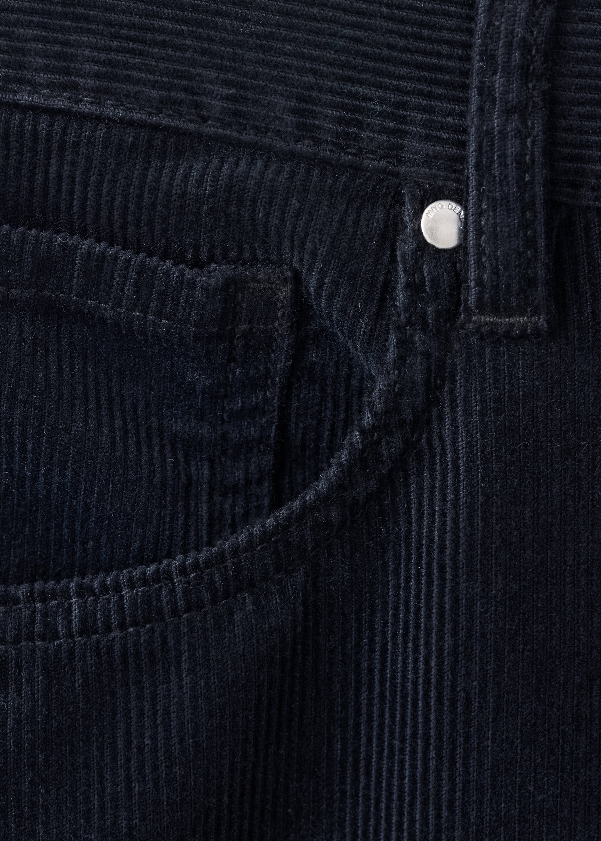 Close-up of dark navy blue corduroy trousers fabric detail.