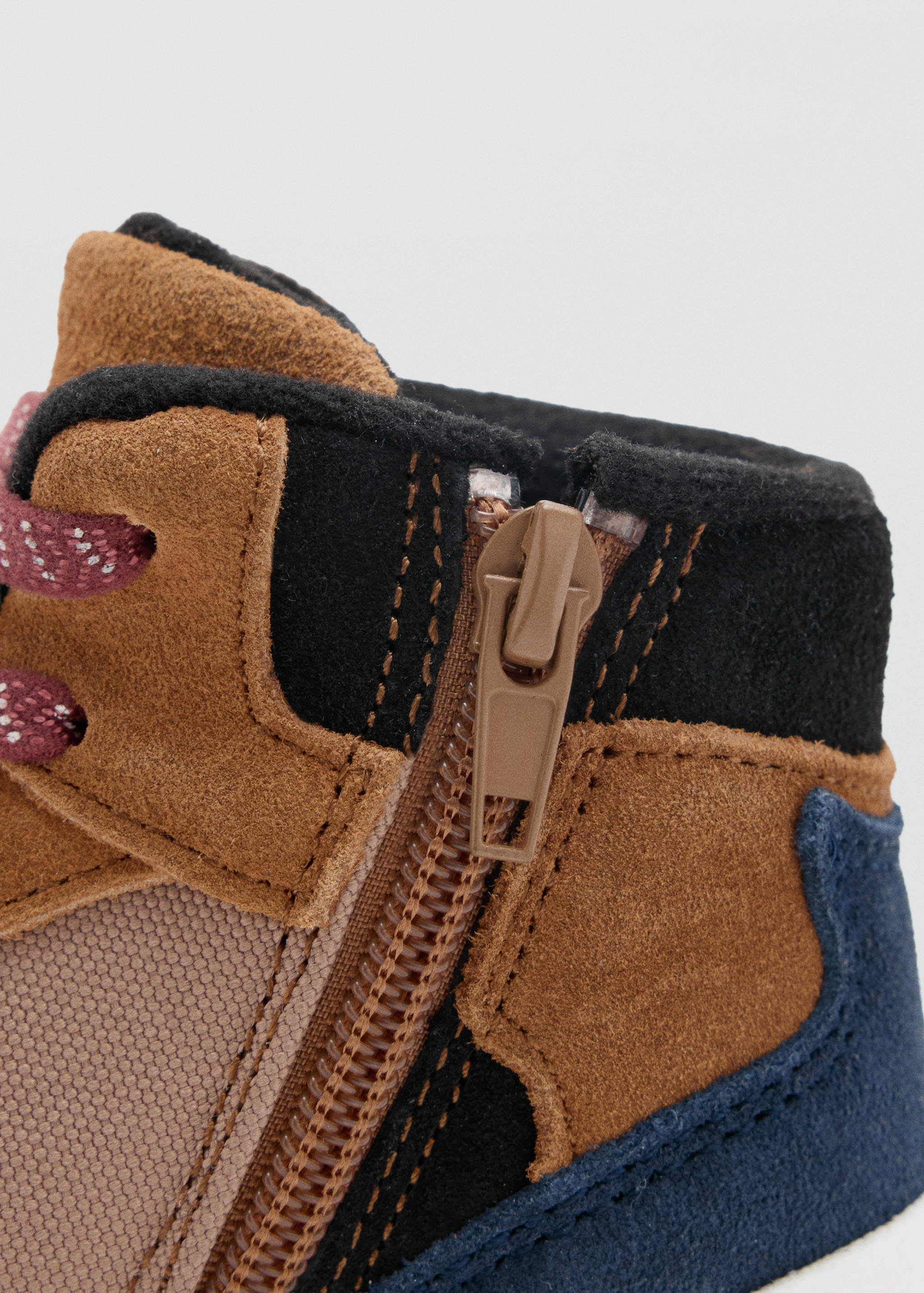 Close-up of the side zipper and panel detail on a multi-coloured boot.