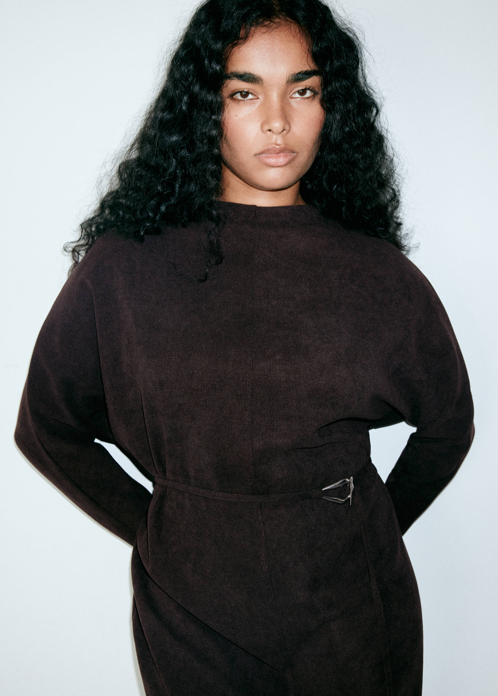 Dark brown long-sleeved dress with a round neck and a buckled belt.
