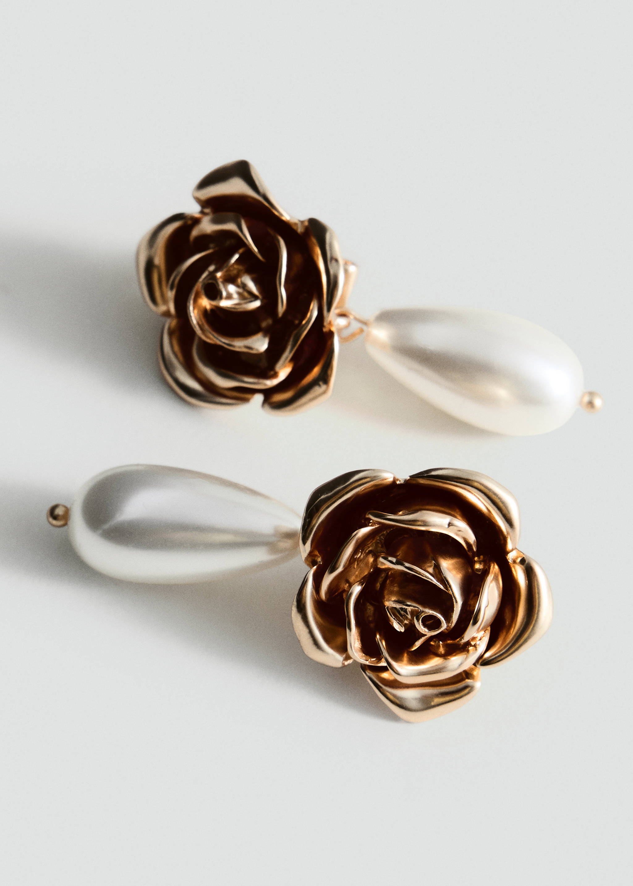 Gold rose earrings with teardrop faux-pearl pendants.