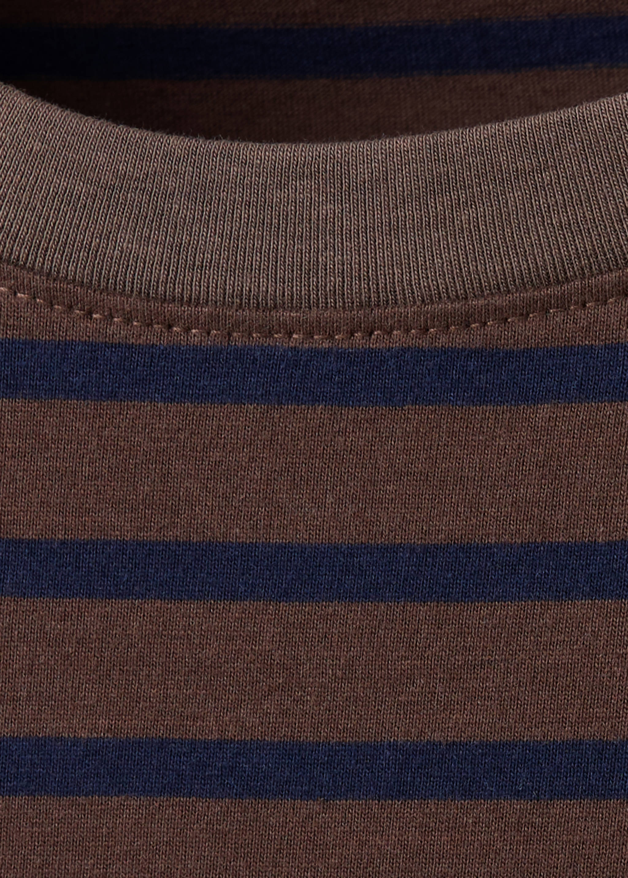 Close-up of a brown and dark blue striped t-shirt neckline.
