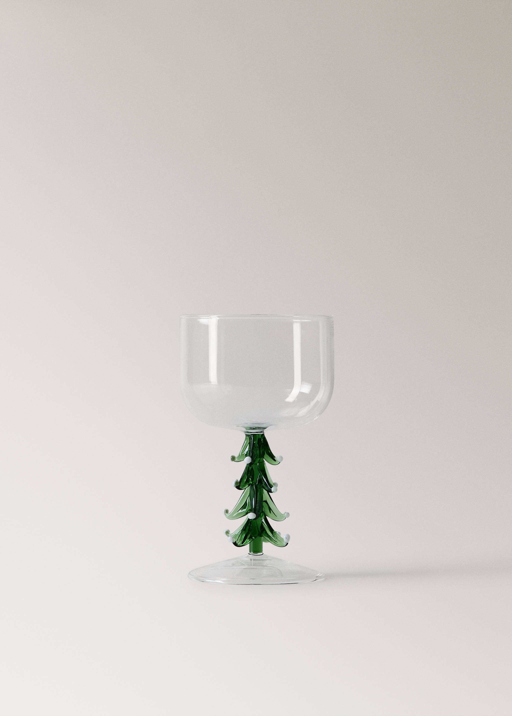 Clear glass goblet with a green tree-shaped stem and white accents.