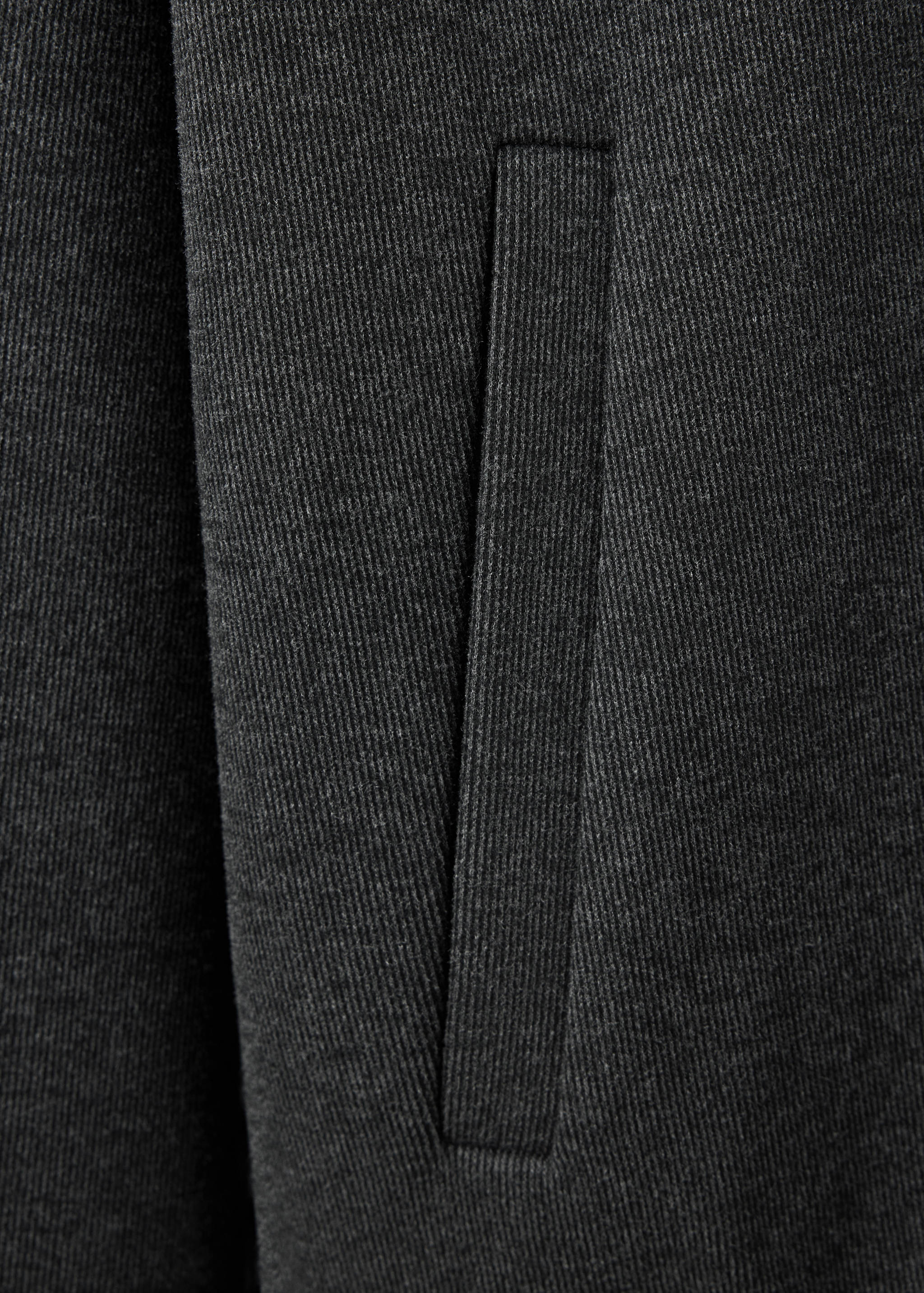 Close-up of dark grey sweatshirt fabric and pocket detail.