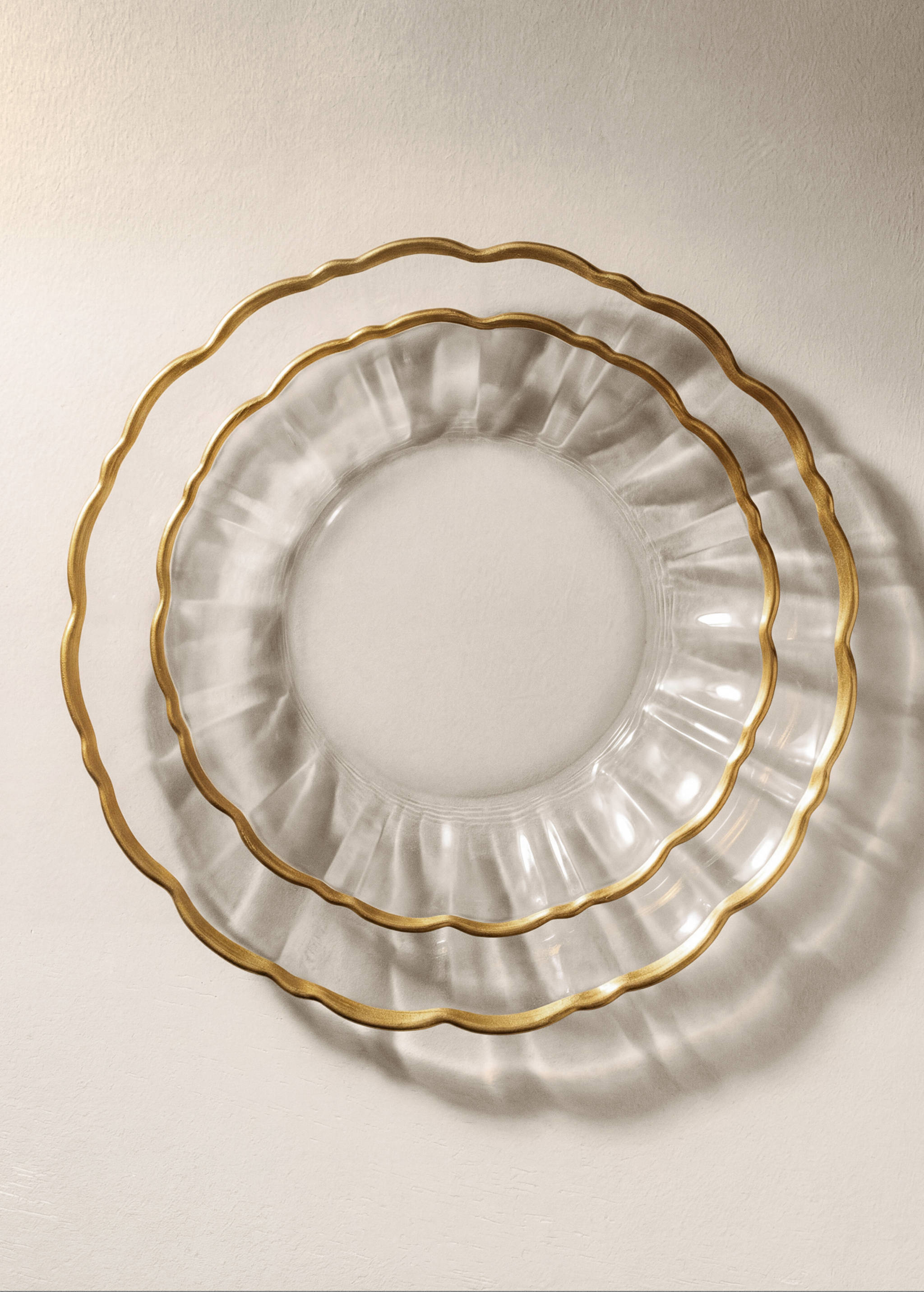Clear glass plates with scalloped rims and gold edges.