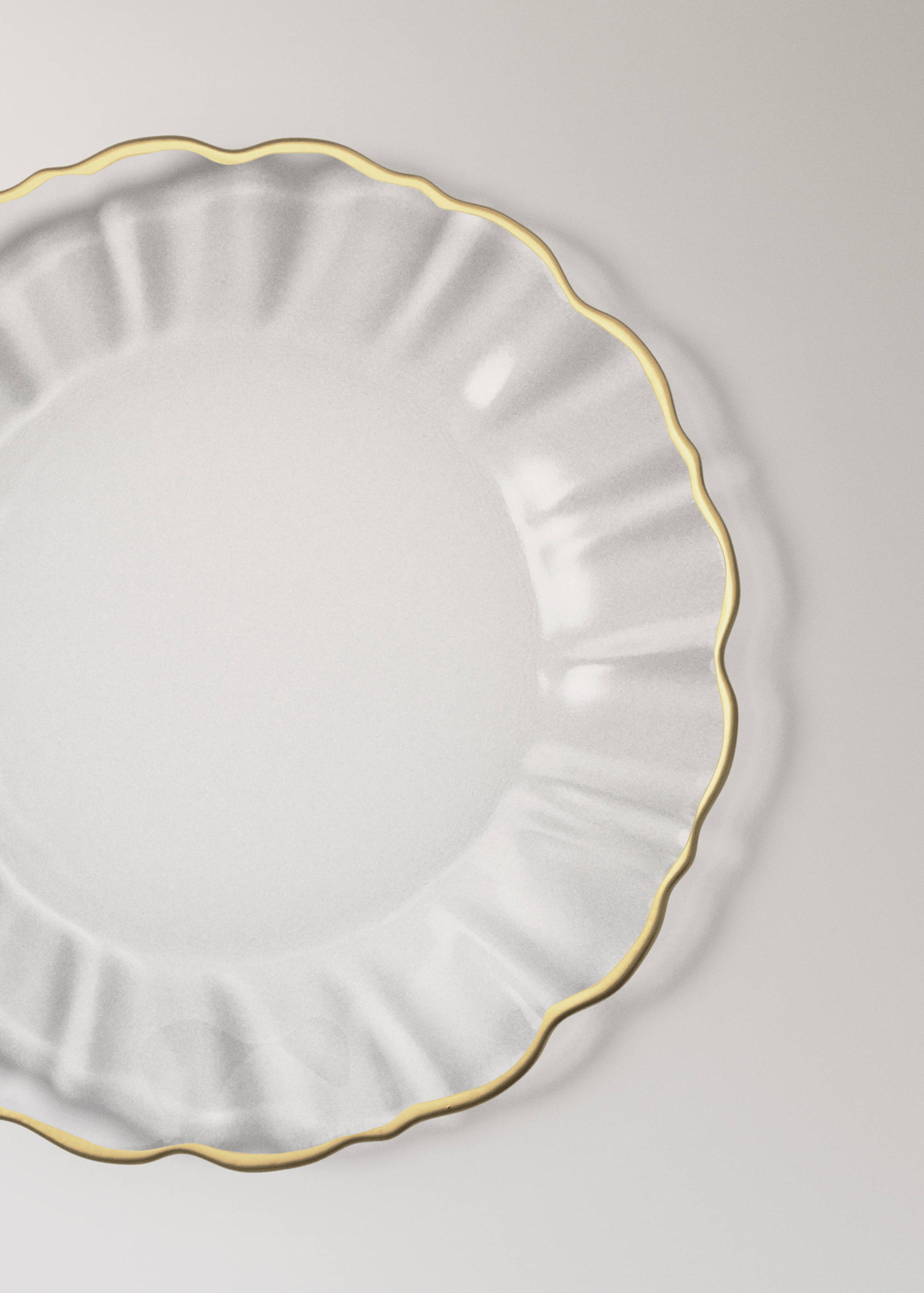 Clear glass plate with a fluted rim and gold-coloured trim.