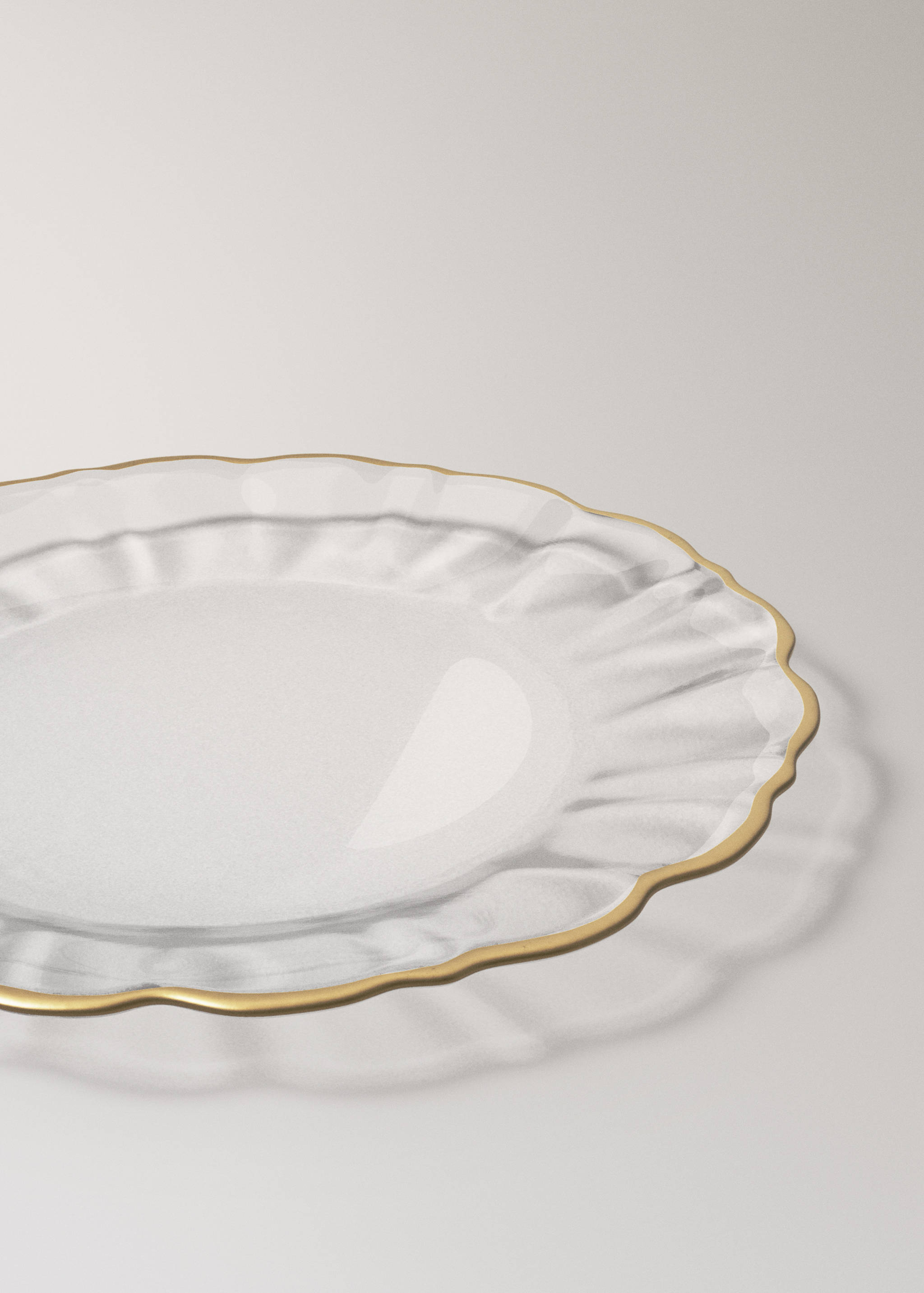Clear glass plate with a scalloped rim and a gold-coloured edge.