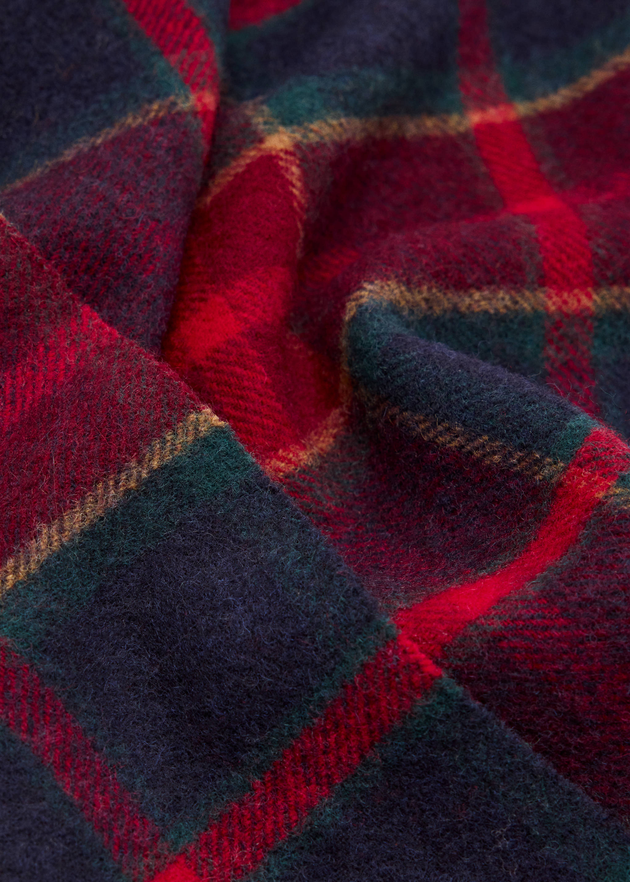 Scarf with a navy, red, and green plaid pattern in textured fabric.