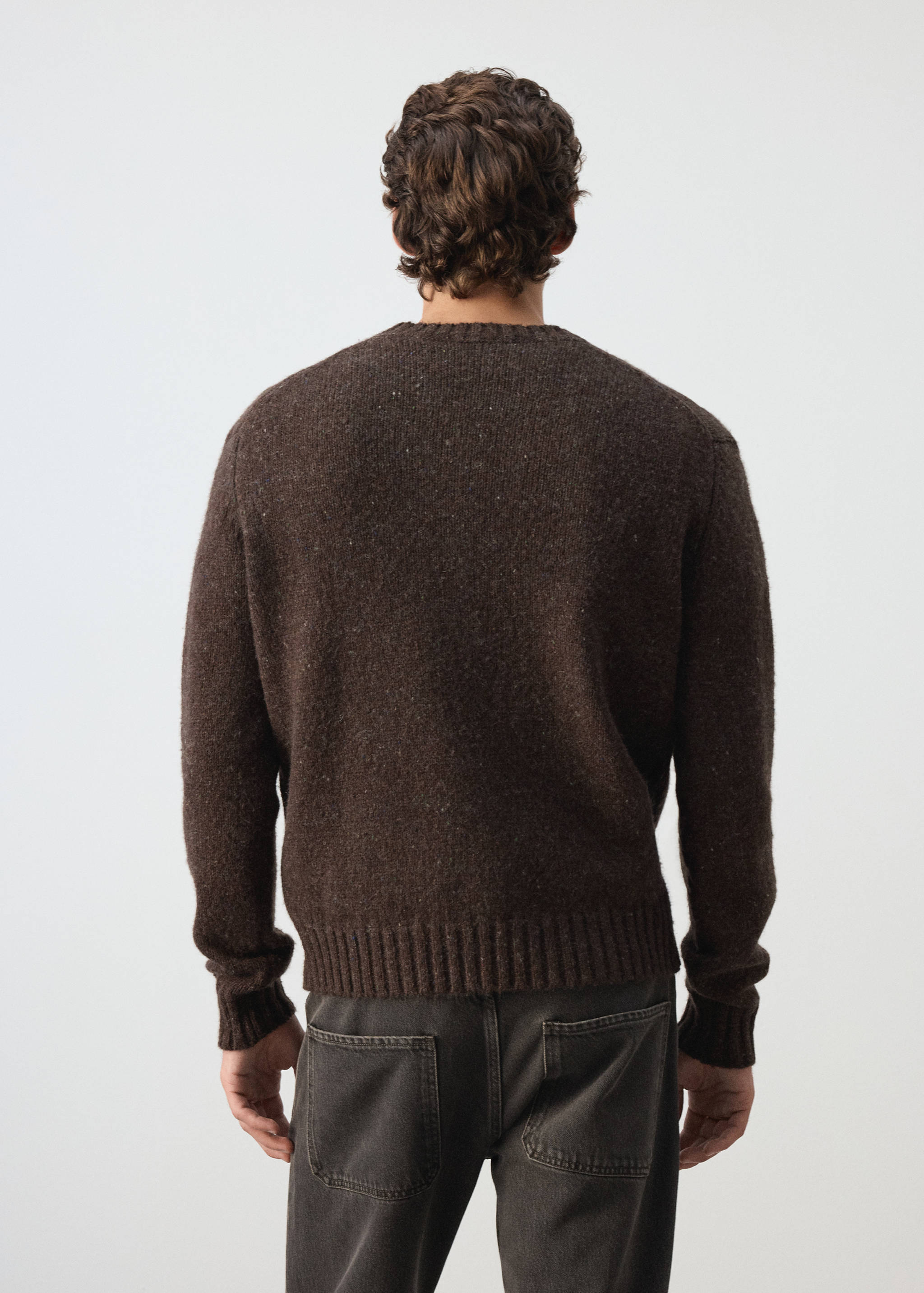 Dark brown knitted sweater with a crew neck, seen from the back.