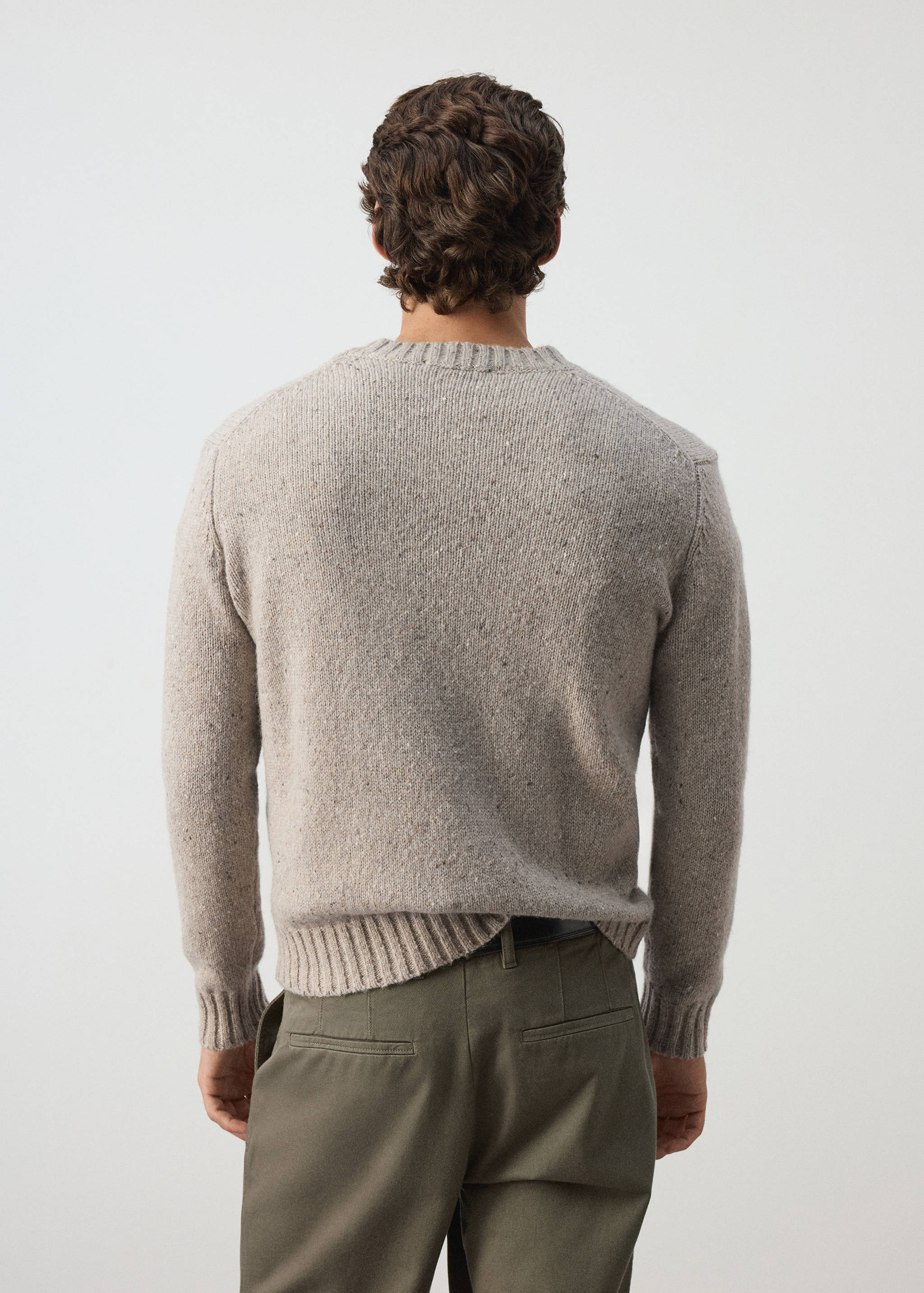 Back view of a light beige speckled knit jumper with ribbed trim.