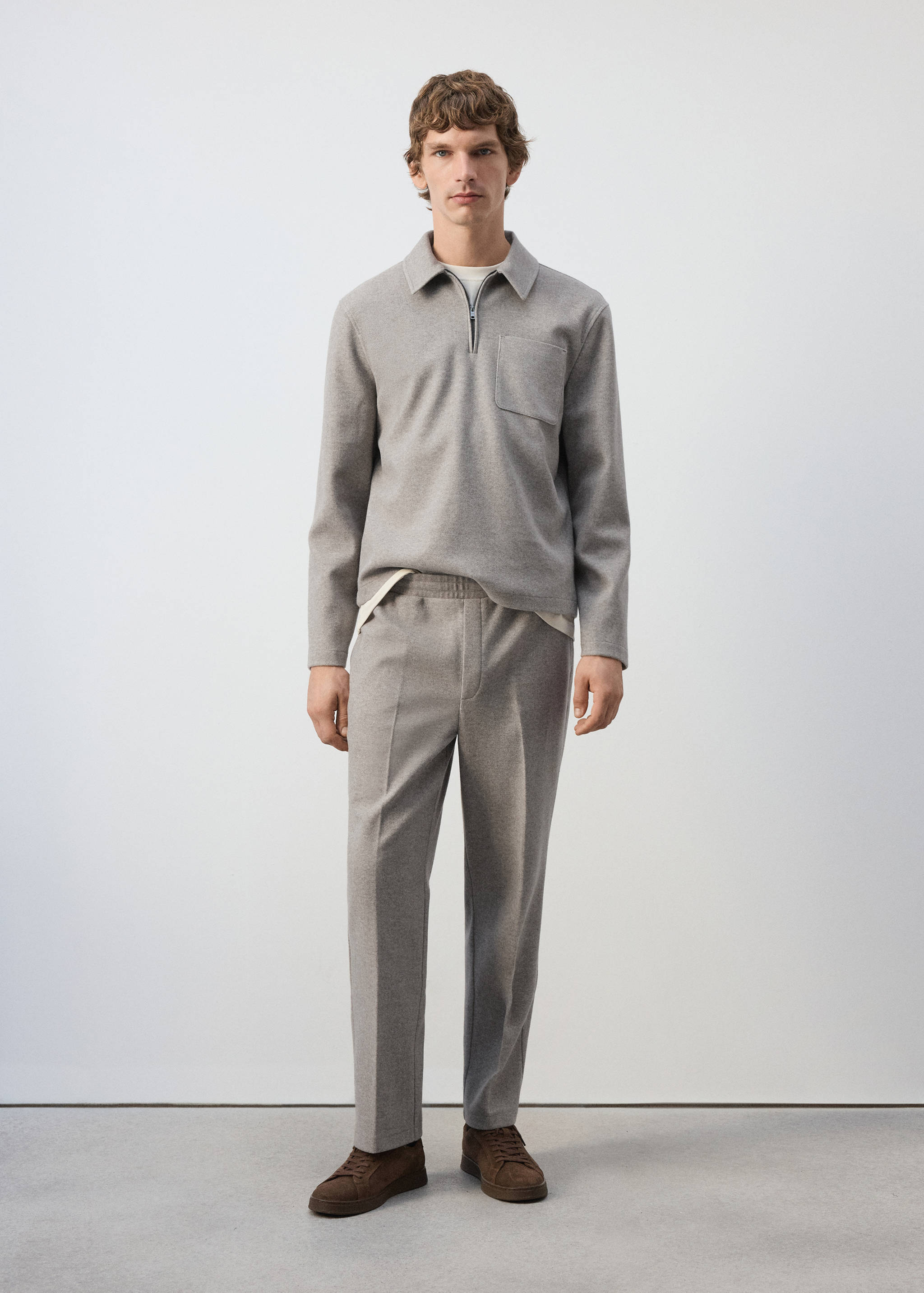 Grey joggers with an elasticated waist, styled with a matching half-zip polo shirt.