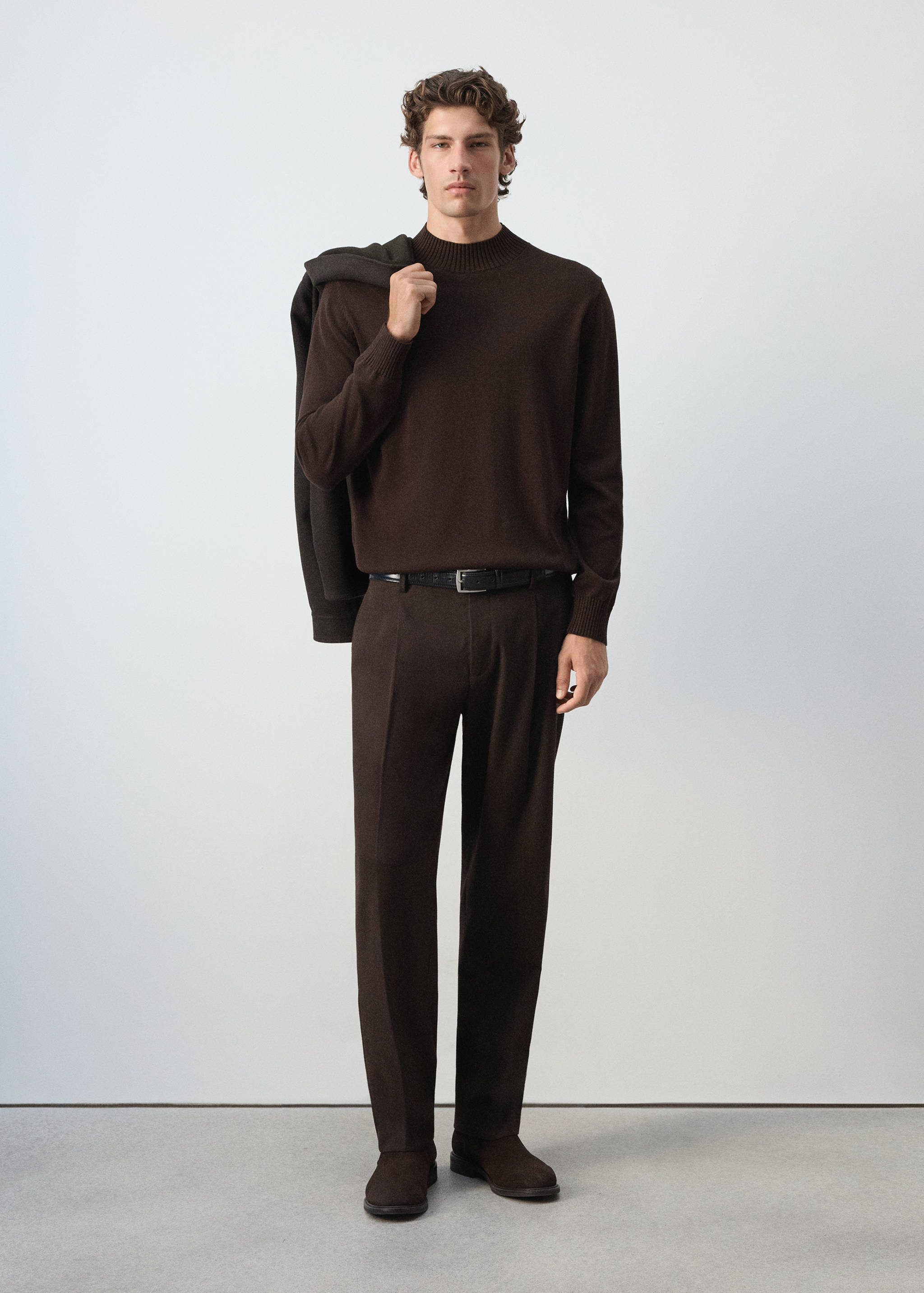 Dark brown long-sleeved jersey with a mock neckline, worn with matching trousers.