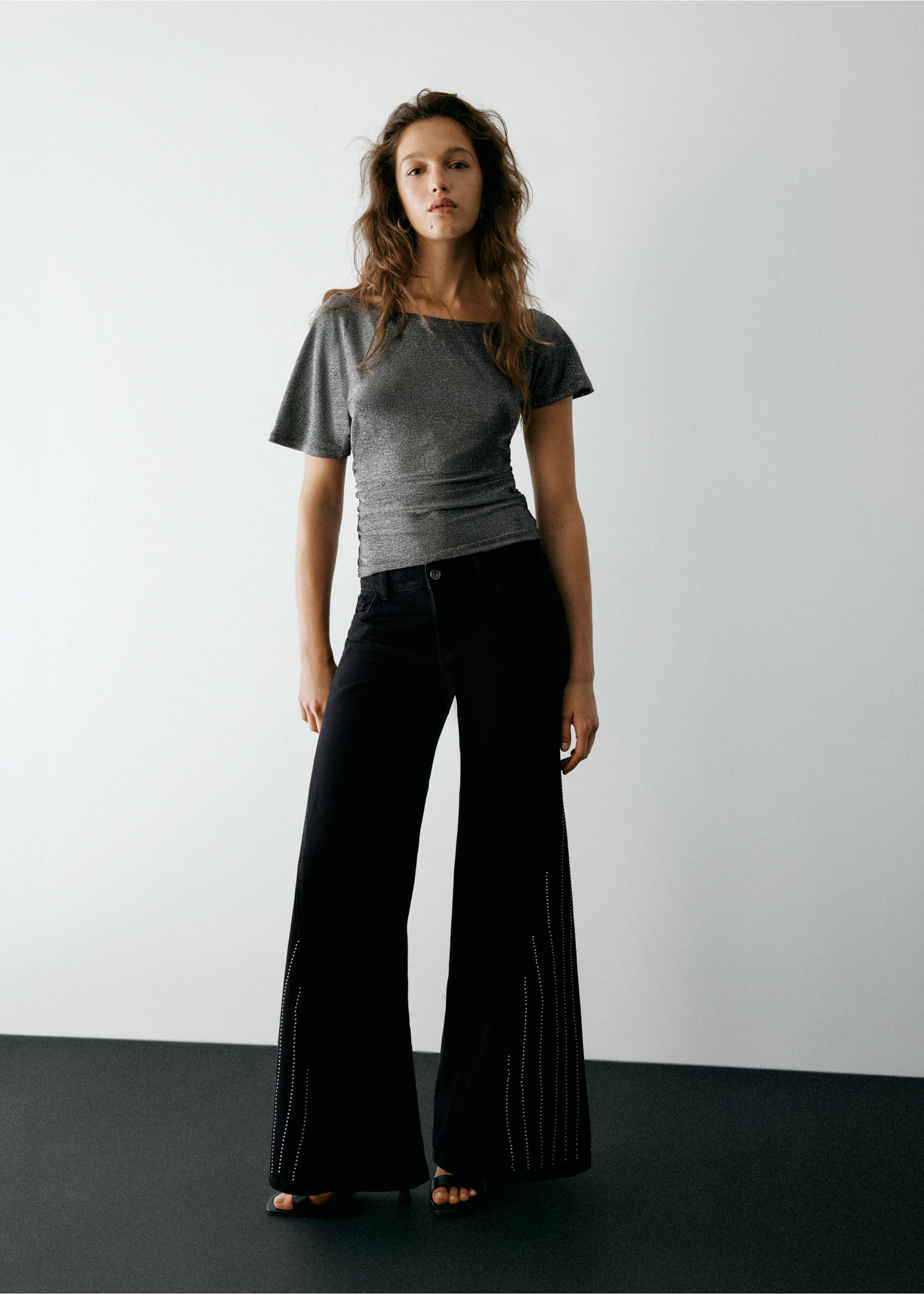 Black wide-leg denim trousers with studded hem details, worn with a grey top., Black. Ref: 37037922-00.
