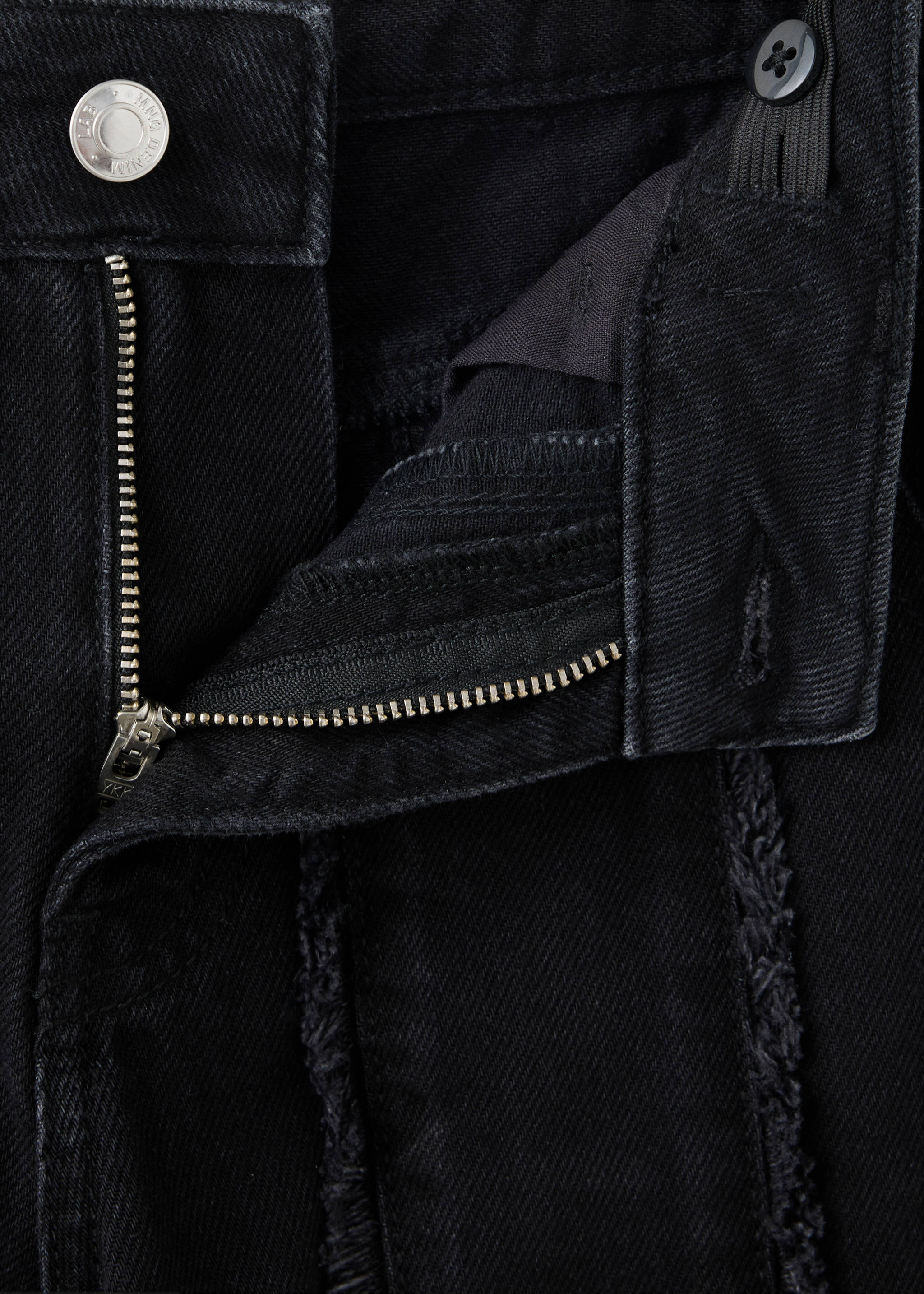 Black denim trousers fabric detail showcasing the zip fly and frayed seams, Black denim. Ref: 37037933-00.