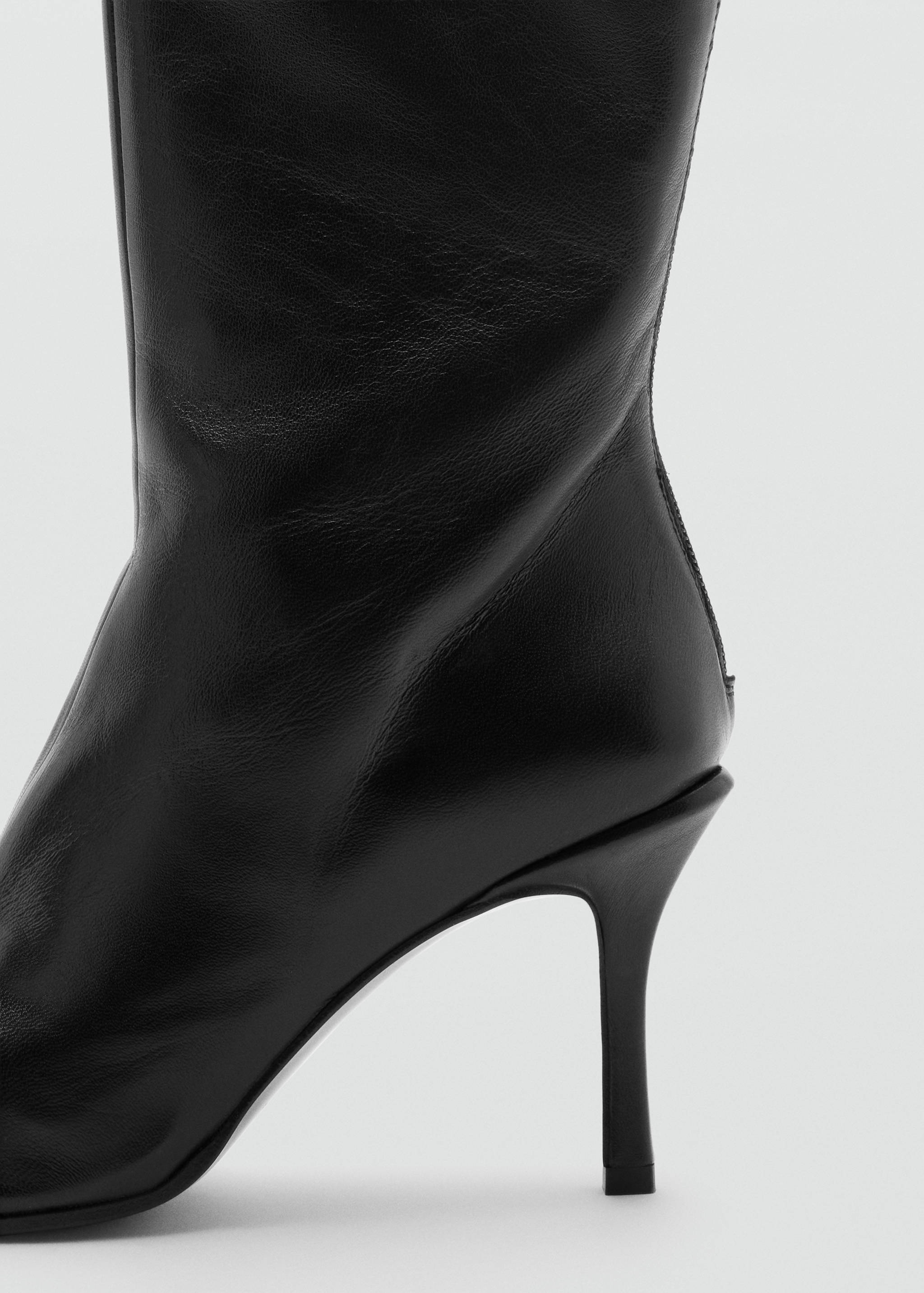 Close-up of a black leather boot heel and ankle detail.