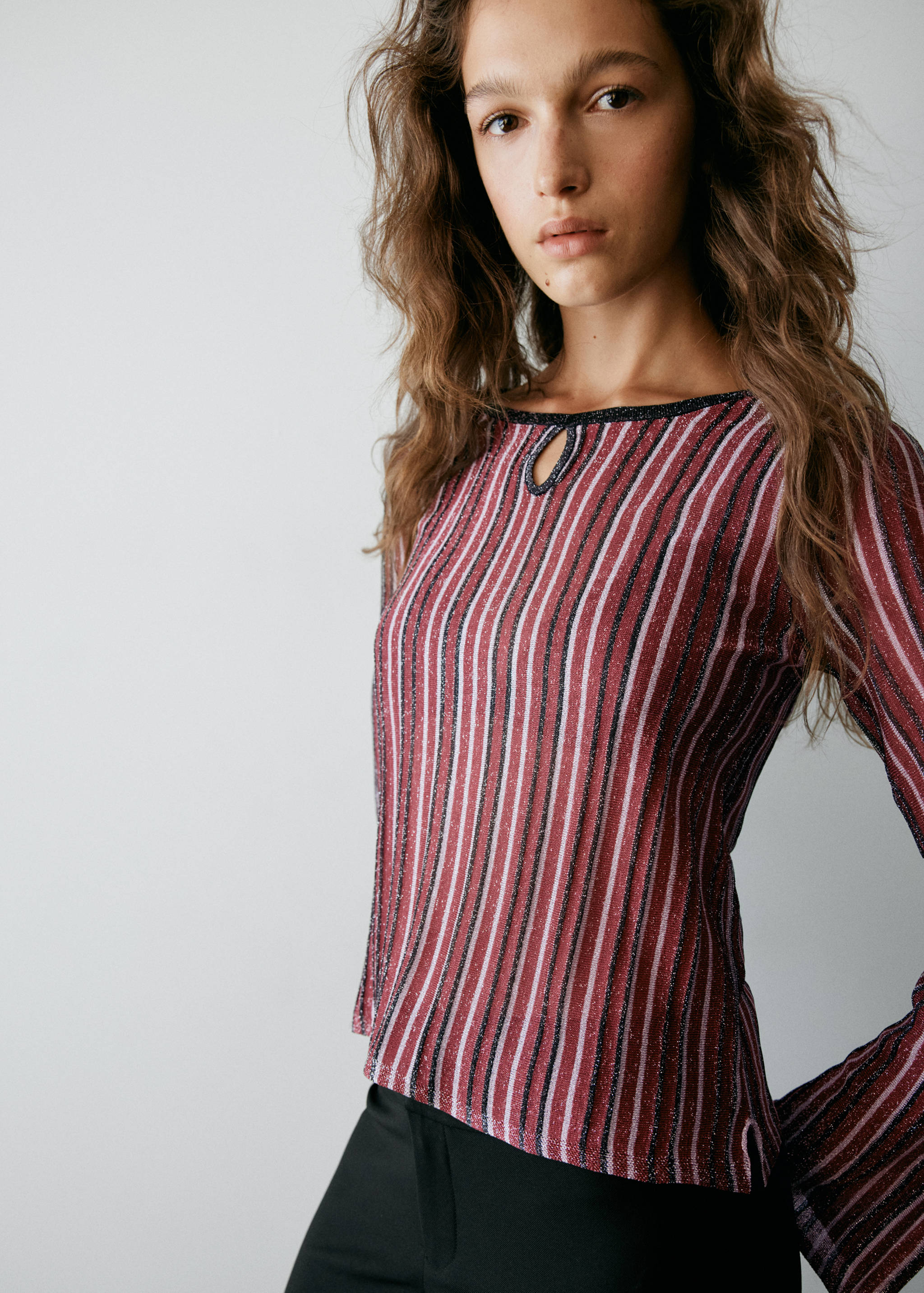 Striped metallic jersey with boat neck, teardrop keyhole, and long flared sleeves.