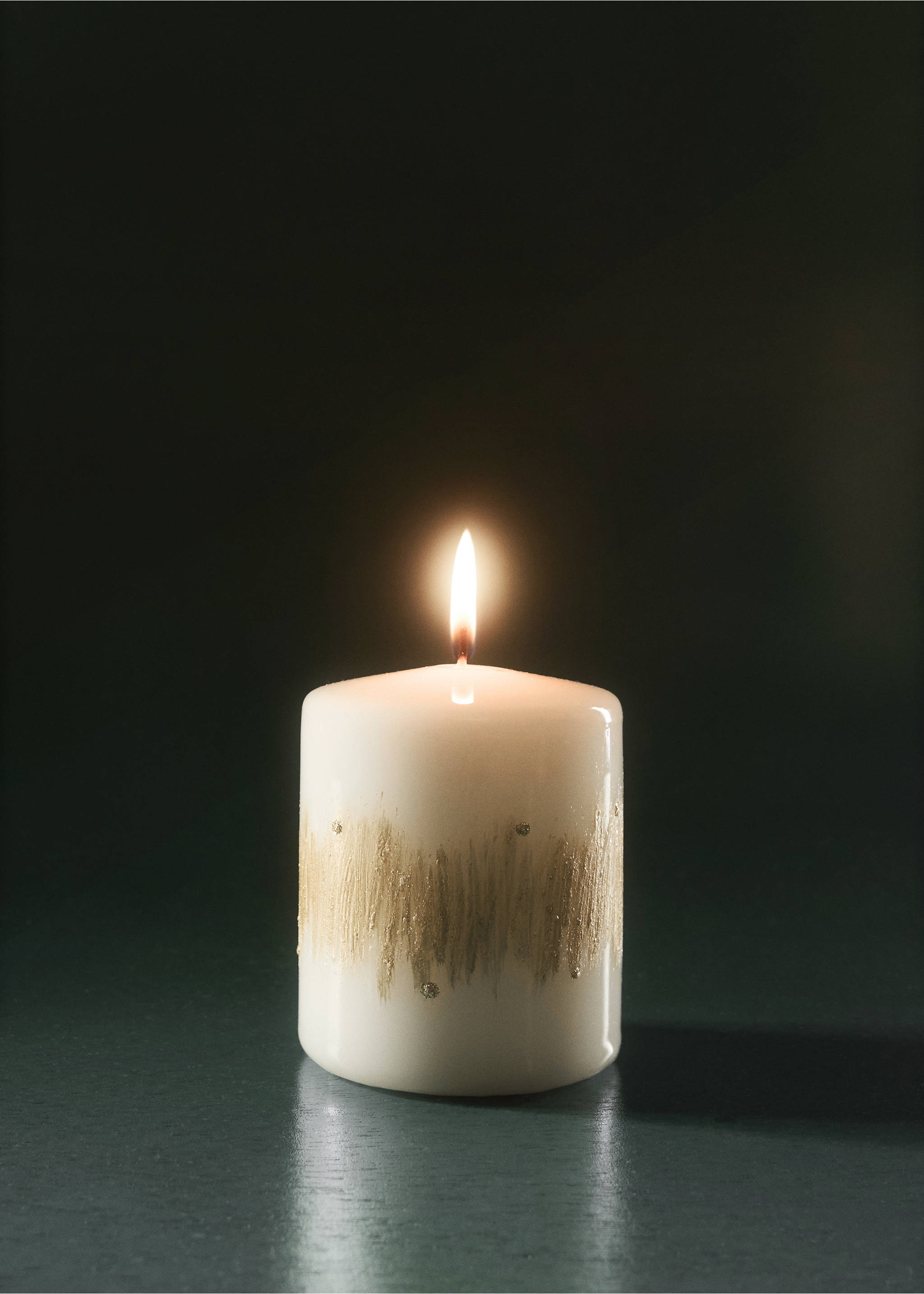 Lit white pillar candle with a textured gold brushstroke band., Gold. Ref: 37037941-00.
