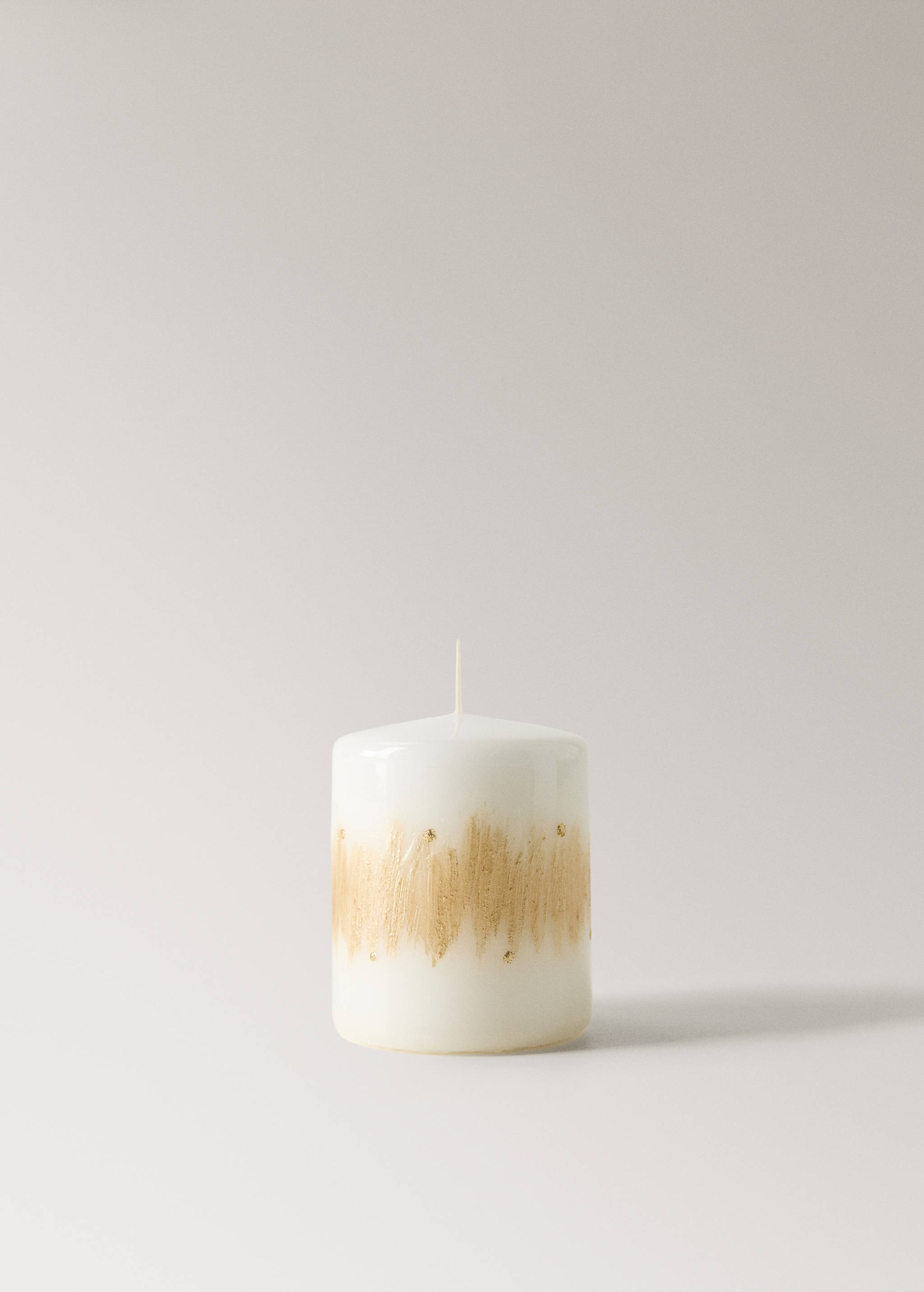 White cylindrical candle featuring a textured metallic gold band around the middle.