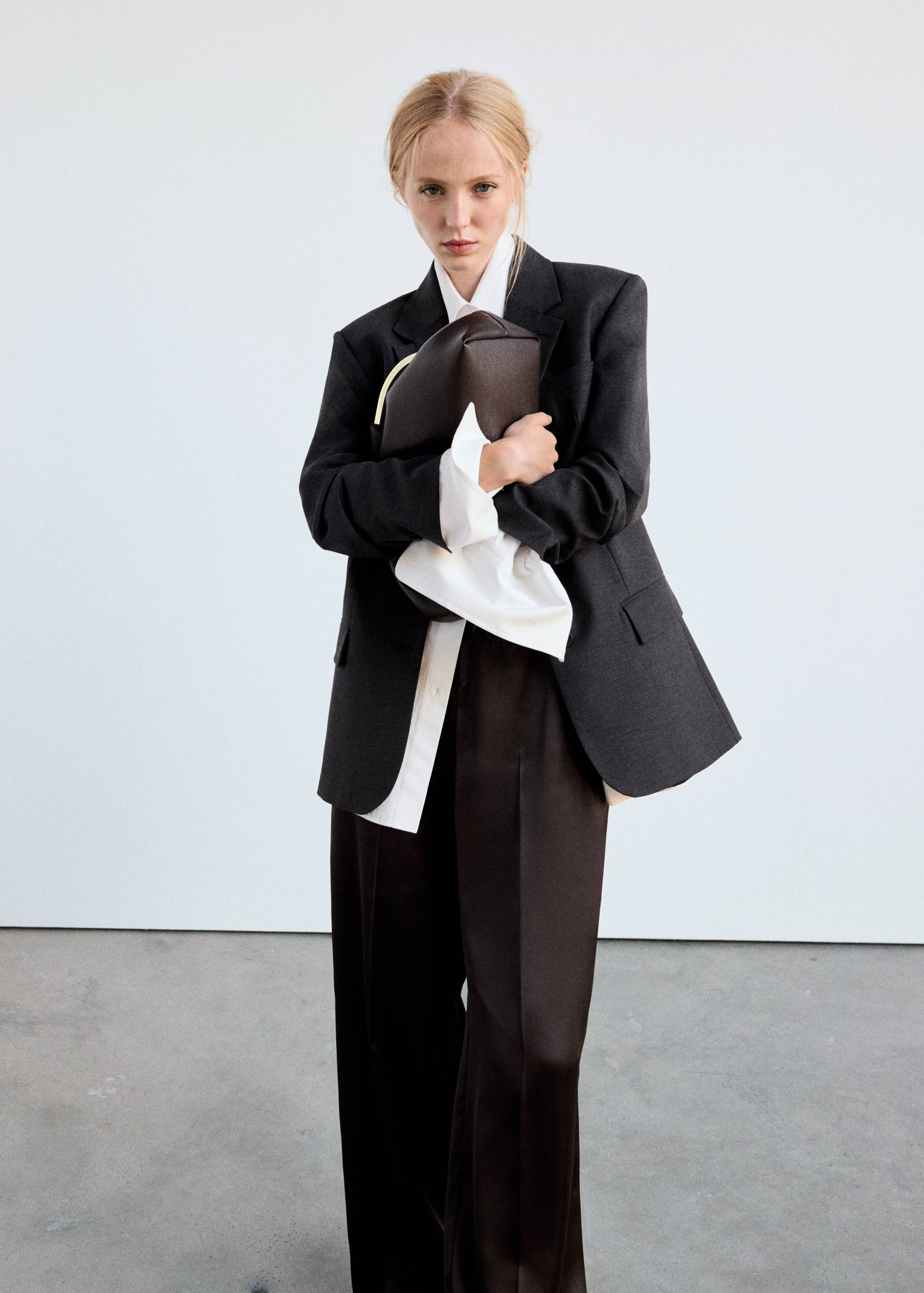Dark brown straight-fit trousers worn with a blazer and white shirt.