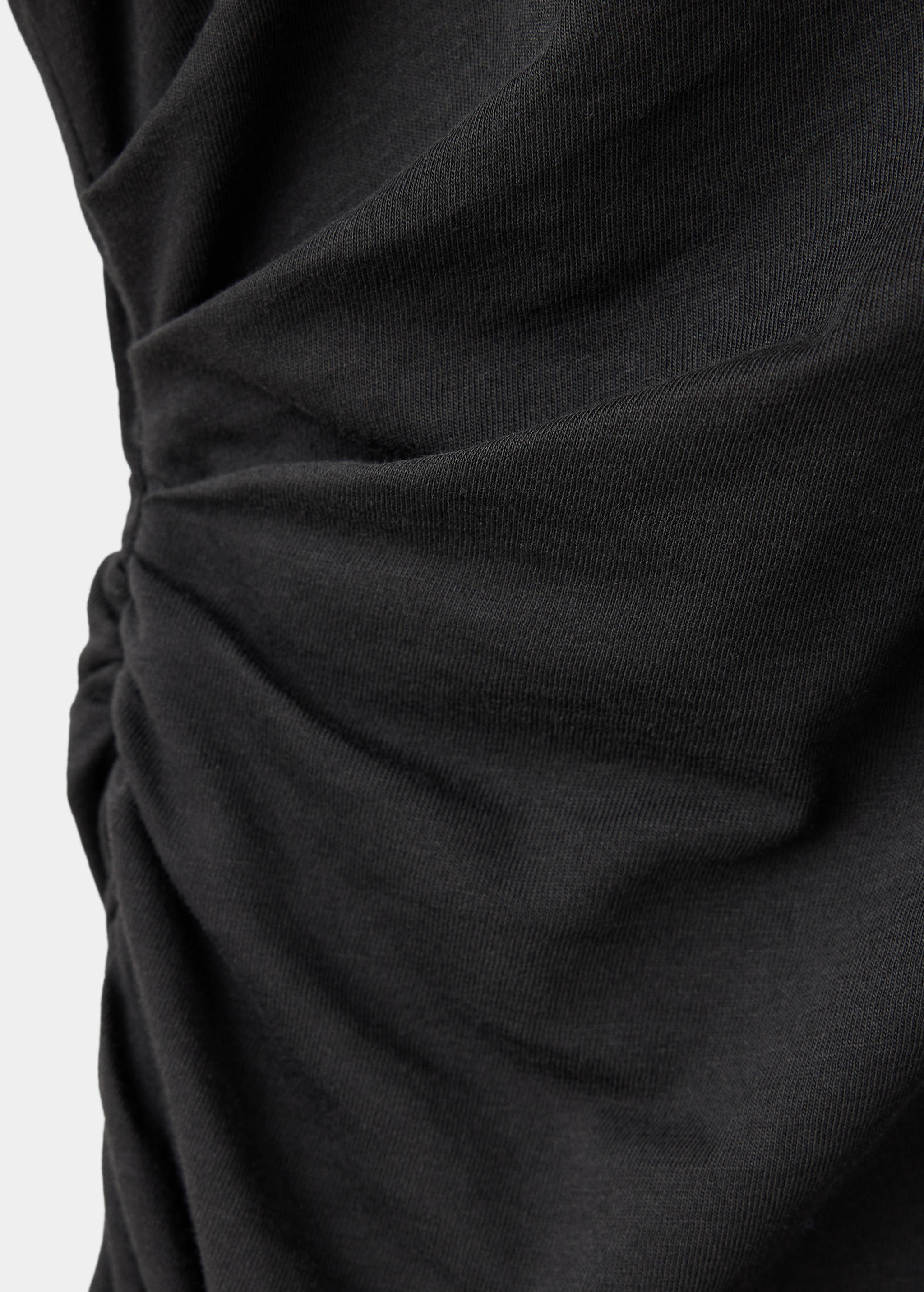 Close-up of black dress with gathered ruched side detail