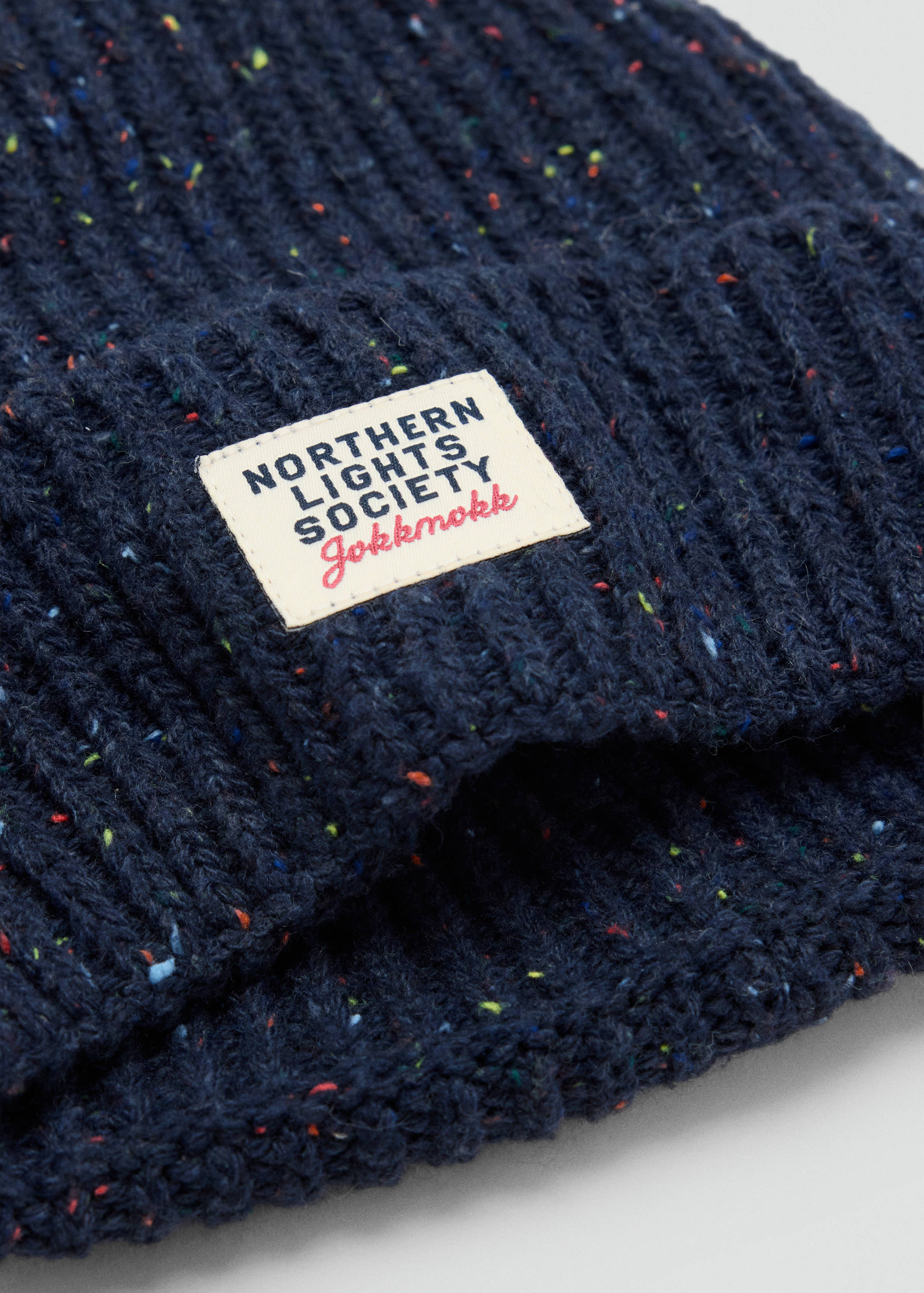 Dark blue flecked ribbed knit beanie with a branded patch.