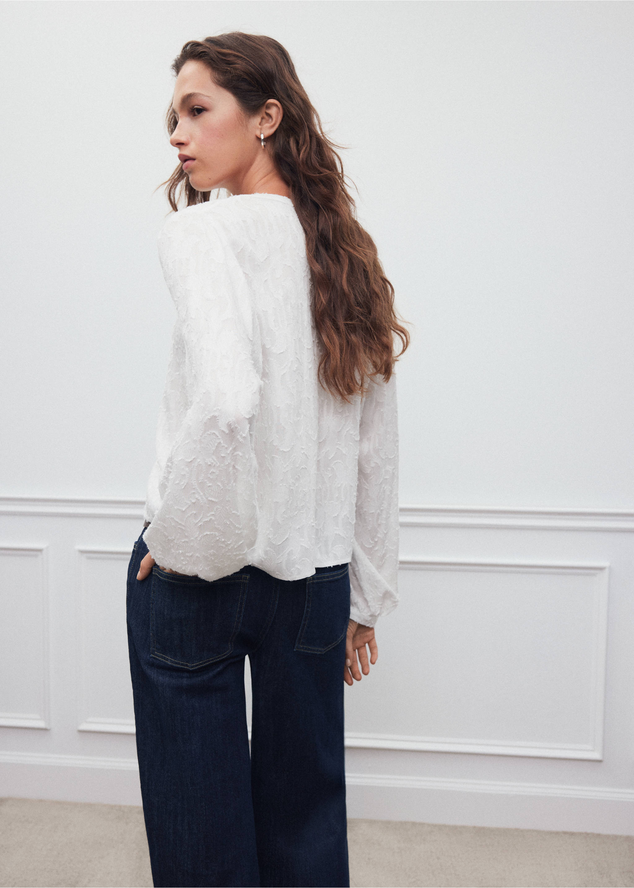 White textured long-sleeve blouse, back view, paired with dark blue denim trousers., Off White. Ref: 37038275-00.