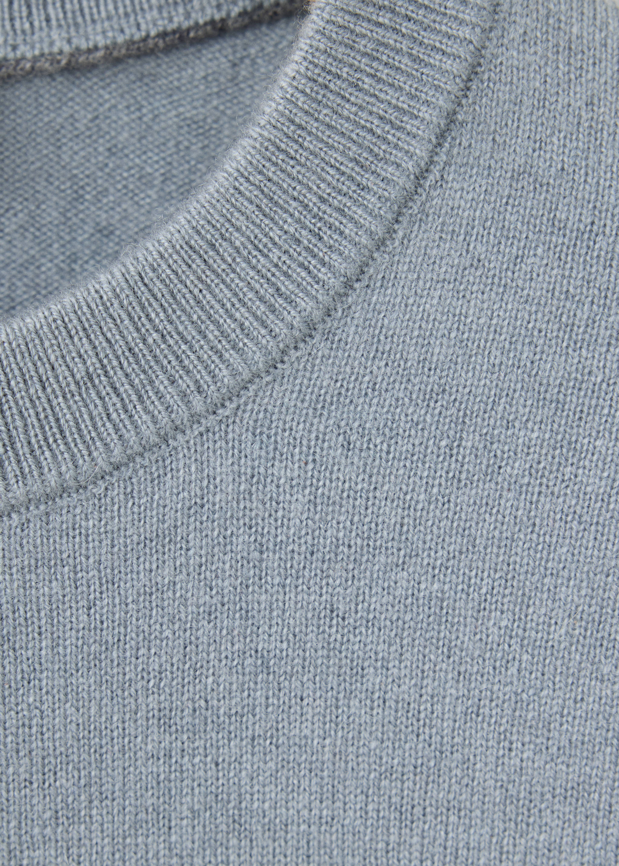 Close-up of a light blue men's jersey with a ribbed round neck.