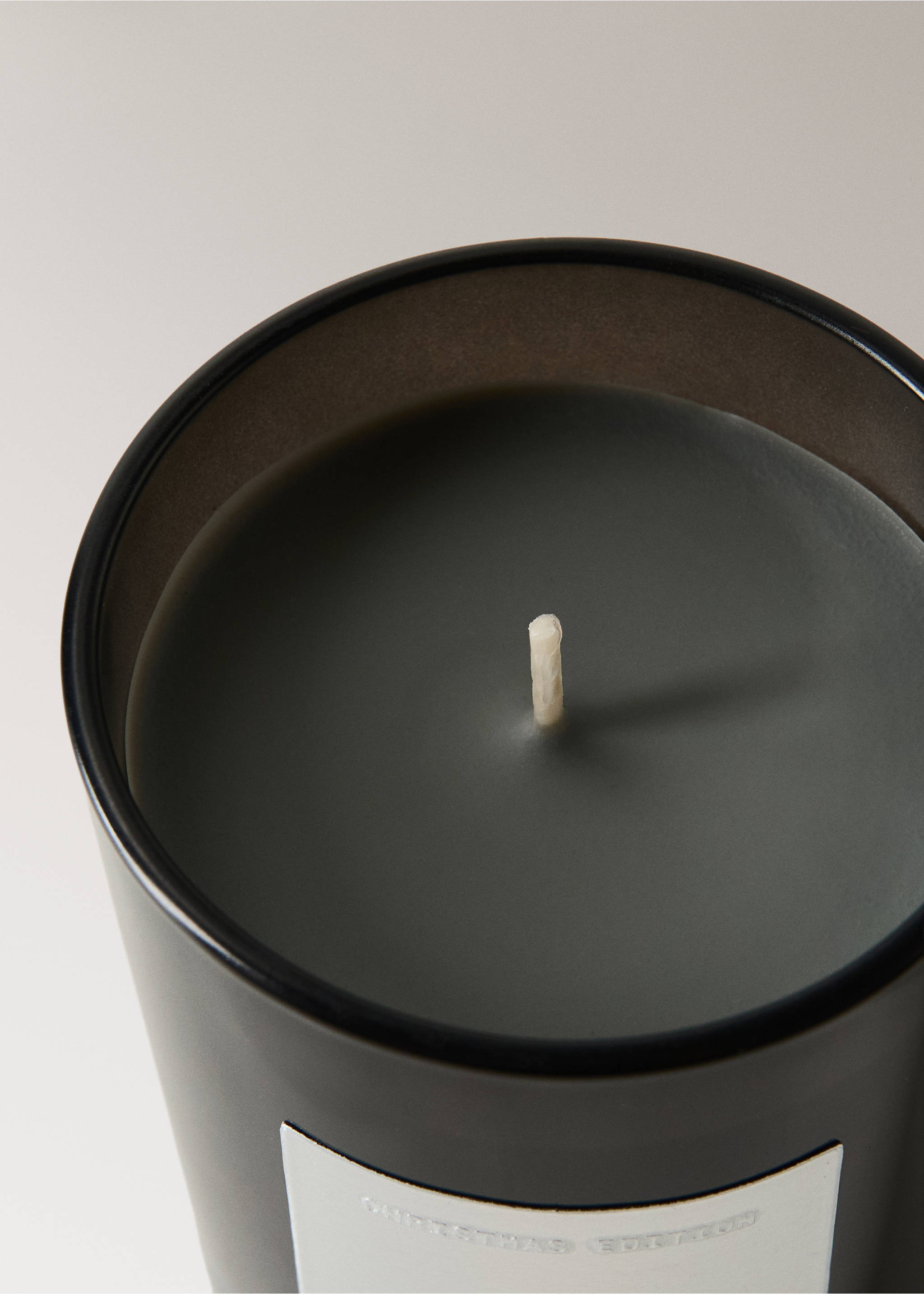 Close-up of a scented candle in a dark grey glass jar with a single wick., Silver. Ref: 37038279-00.