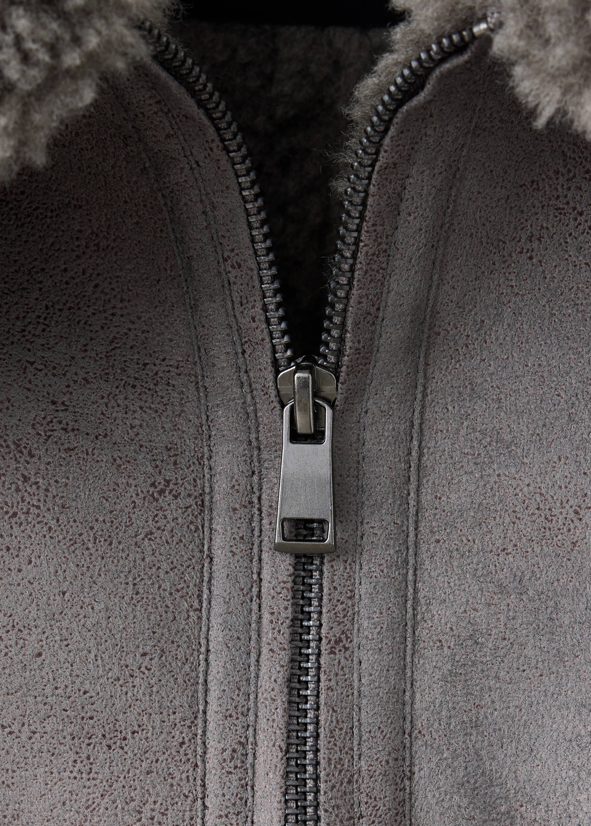 Grey coat zipper and faux-shearling collar detail.
