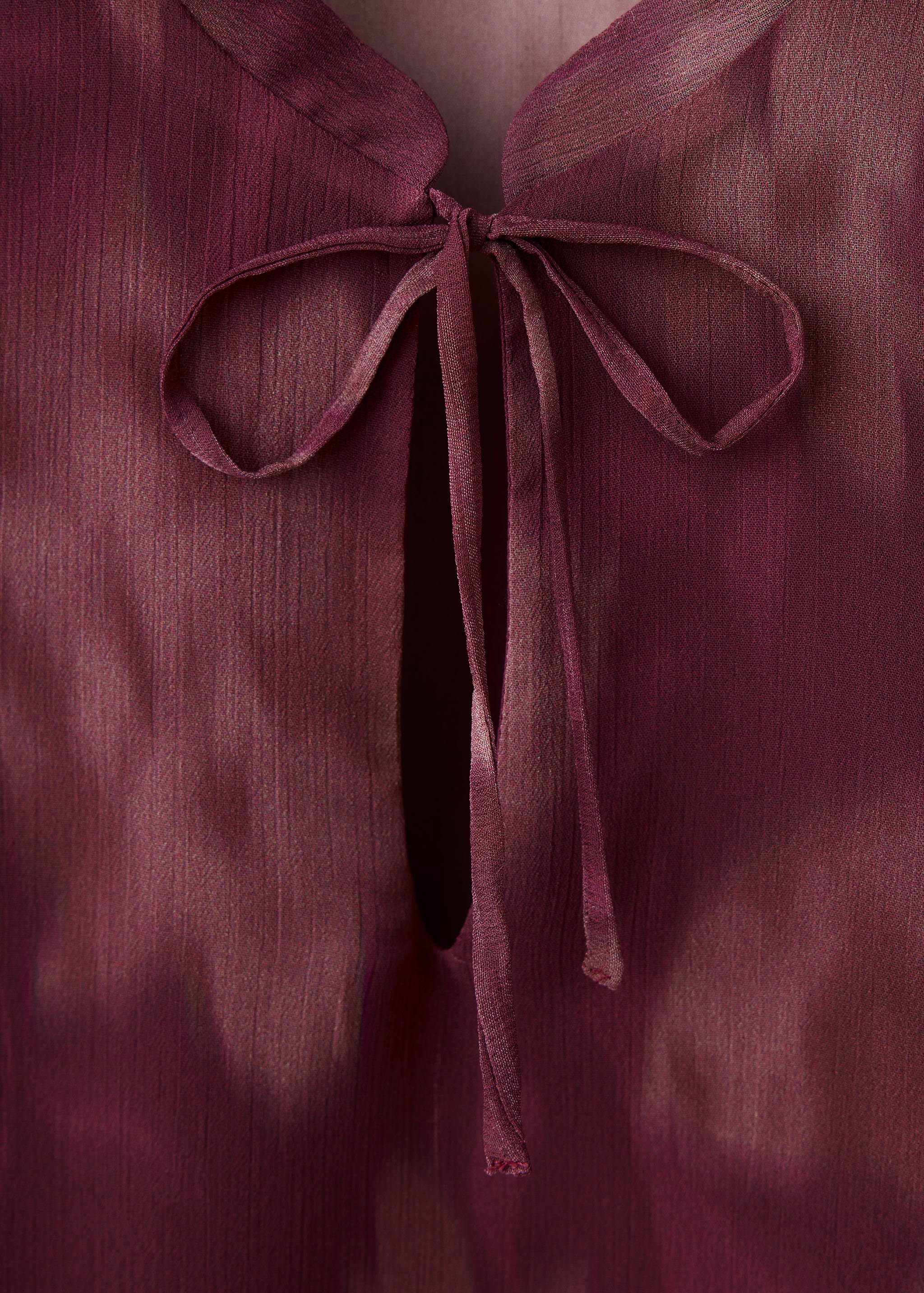 Burgundy shirt featuring a keyhole neckline with self-tie closure.