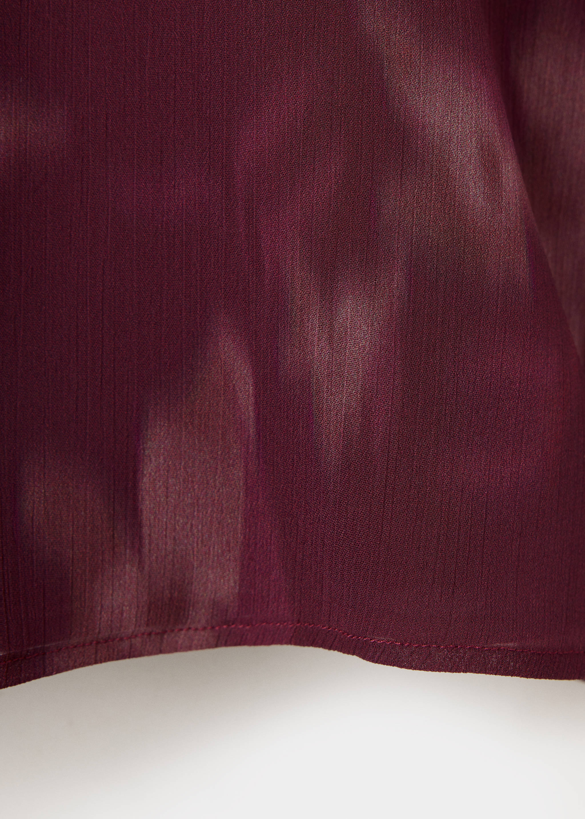 Close-up of the burgundy shirt fabric, showing its subtle vertical texture.