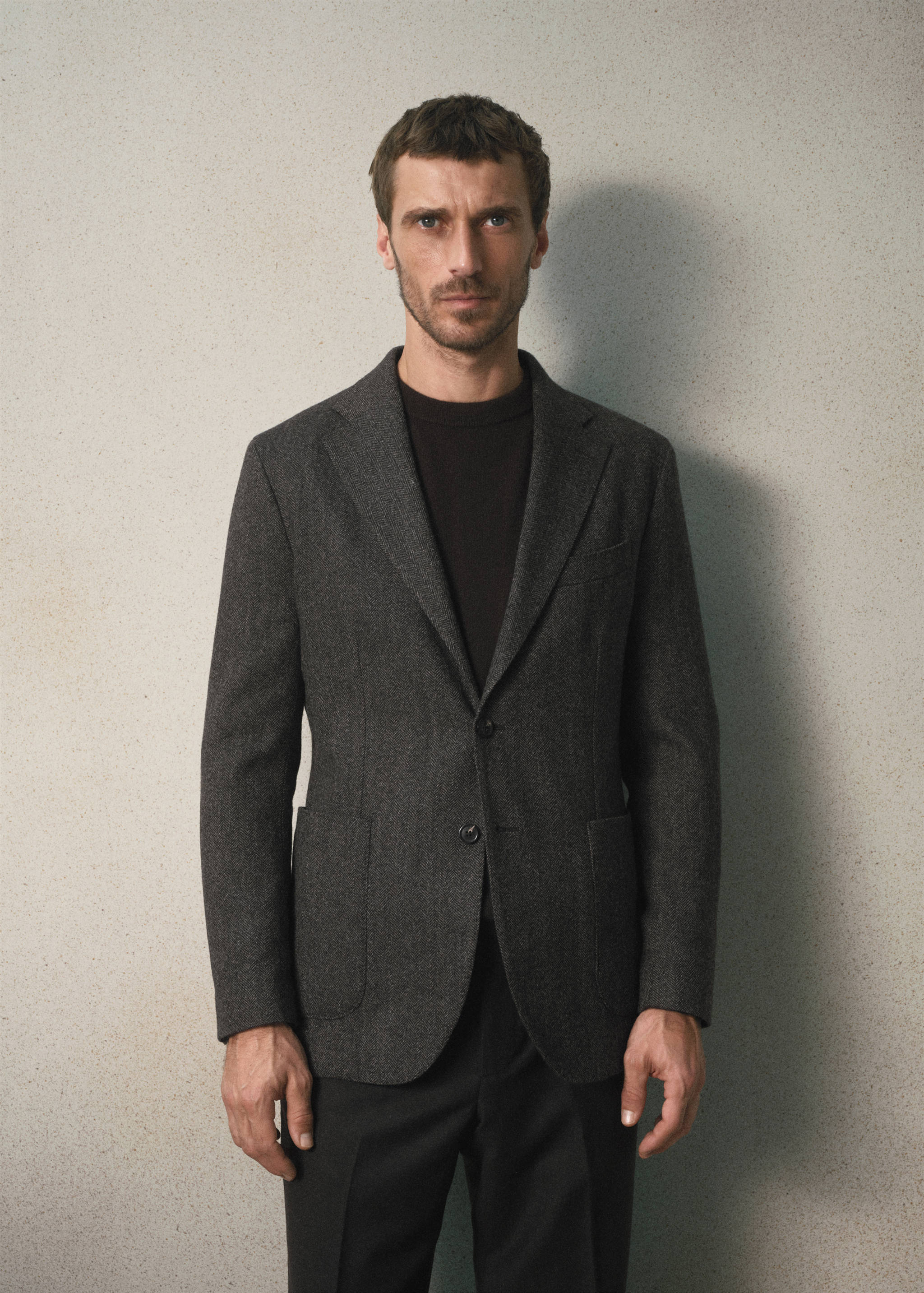 Charcoal grey single-breasted blazer with notch lapels and patch pockets.