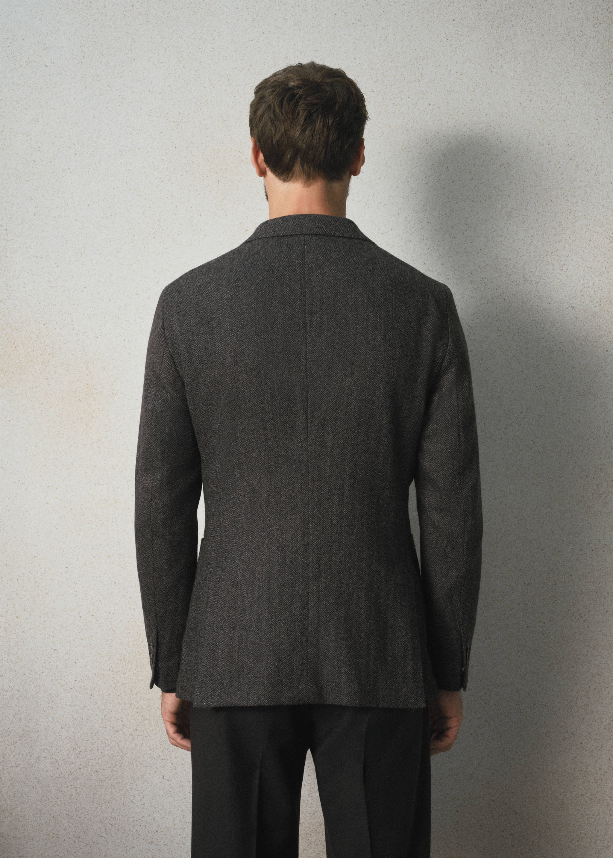 Dark grey textured tailored blazer, back view.
