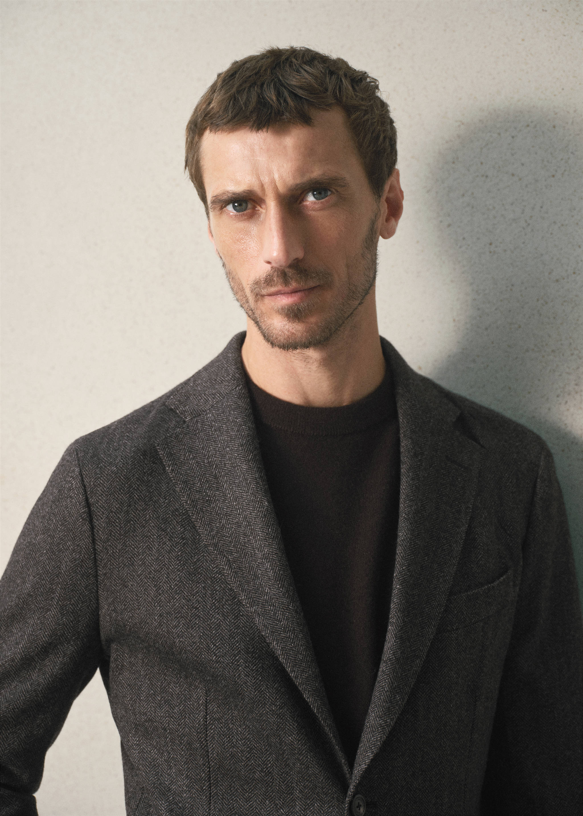 Dark grey herringbone blazer worn over a dark brown t-shirt.